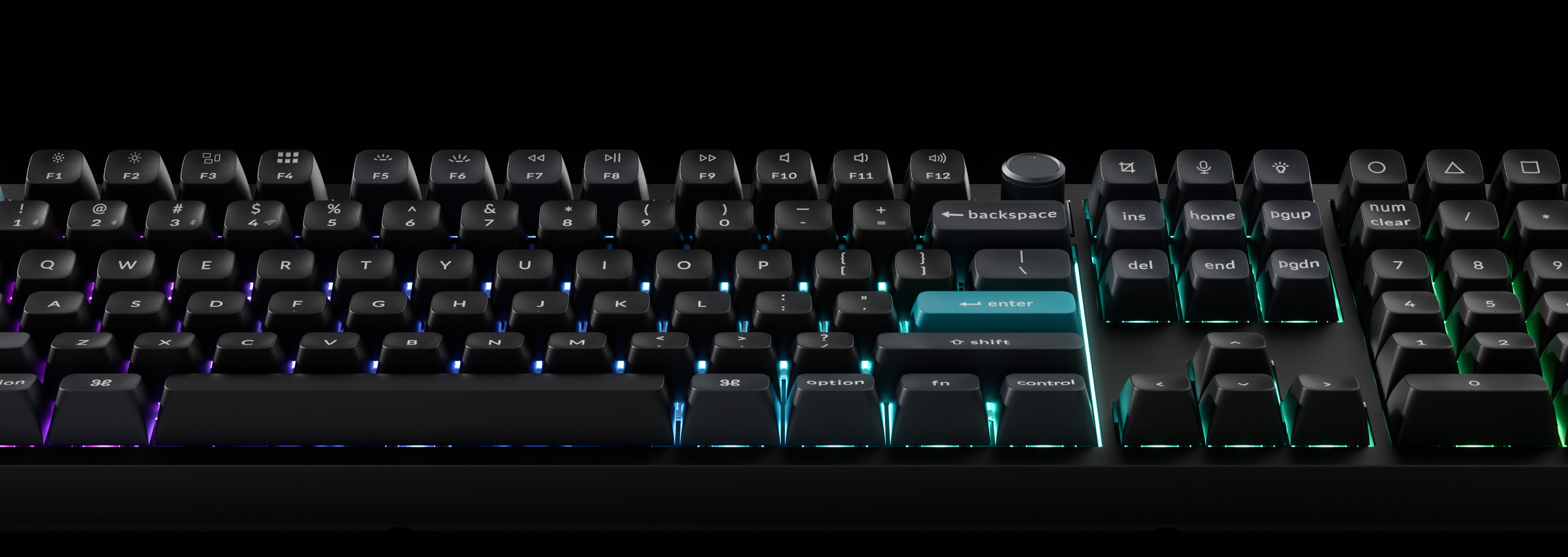 Eine schwarze Tastatur mit beleuchteten Tasten. Die Eingabetaste ist blau, andere Tasten sind mehrfarbig. Schwarzer Hintergrund.