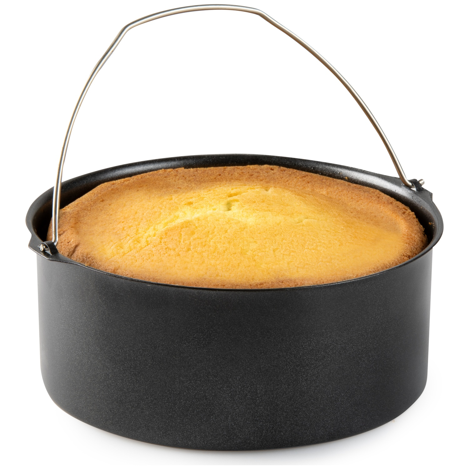 A round, golden cake sits in a black, metal air fryer basket with a silver handle arching over it. The background is white.