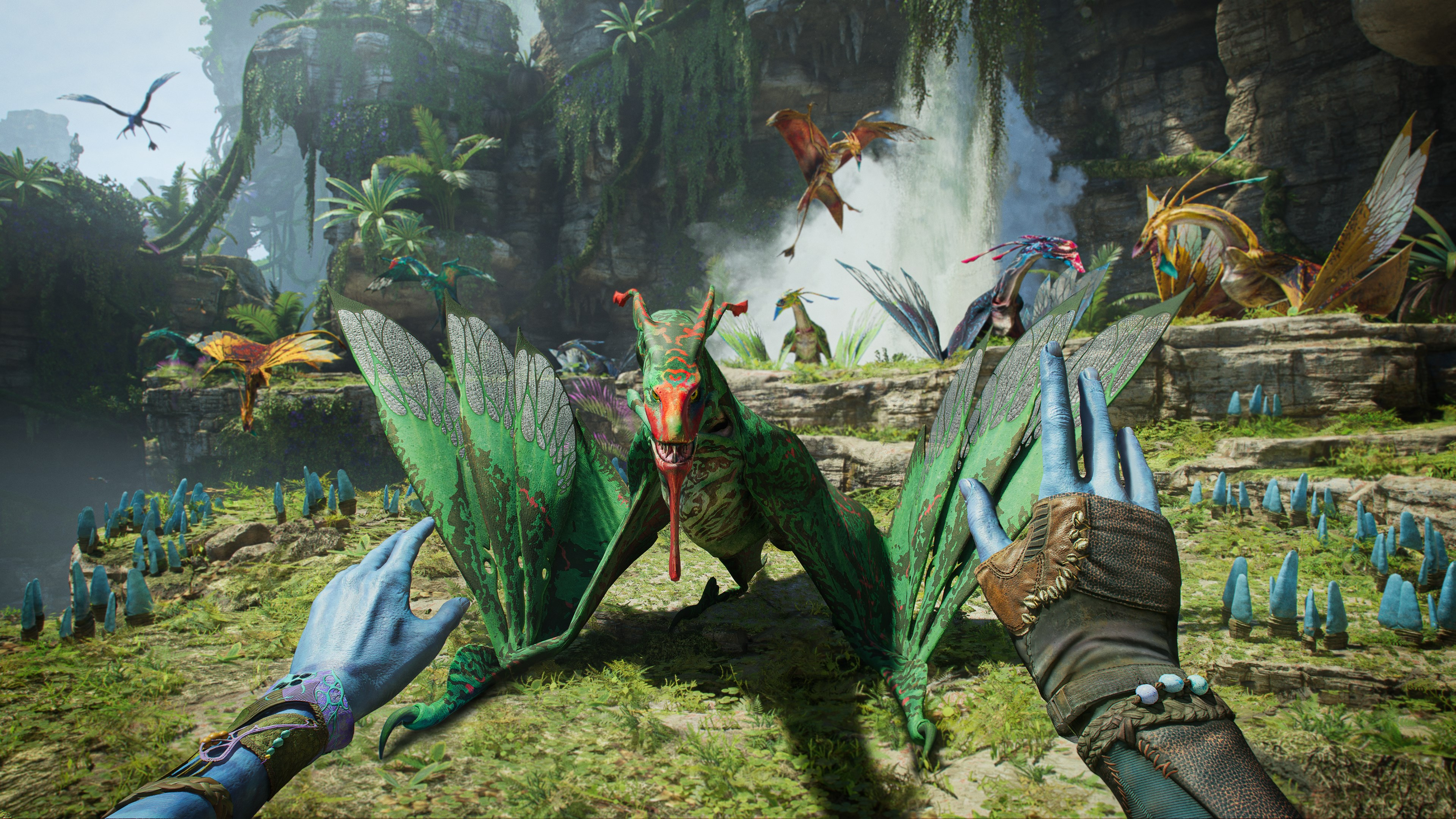 Un drago verde è a fuoco. Mani Avatar. Altri draghi colorati volano intorno a una cascata in un ambiente giungla.