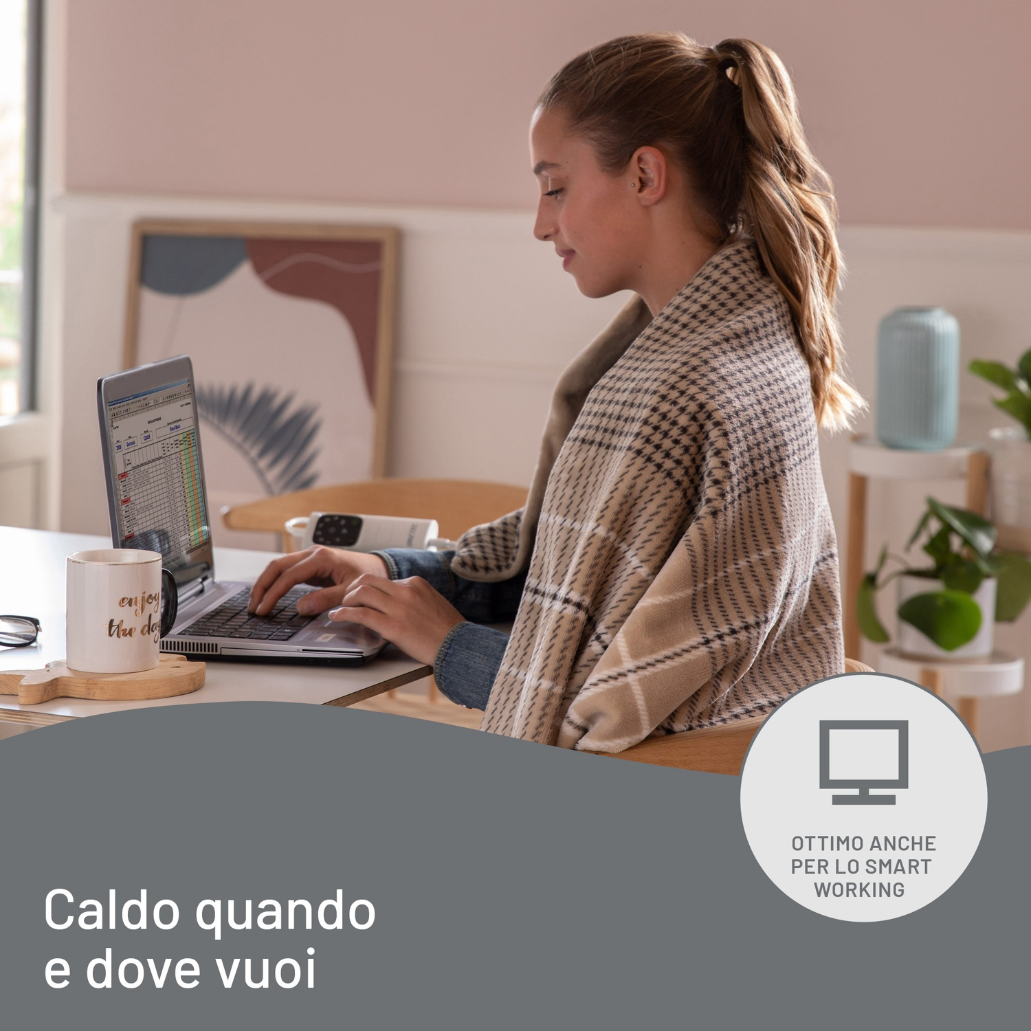 Una donna lavora su un laptop, avvolta in una coperta. C'è una tazza e una pianta nelle vicinanze. Il testo dice "Caldo quando e dove vuoi."