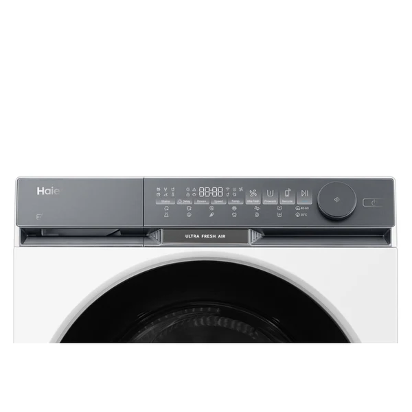Una lavadora Haier blanca con pantalla digital que muestra la hora y ajustes. Tiene un dial redondo a la derecha.