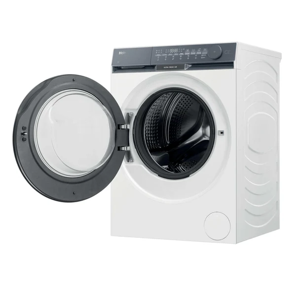 Una lavadora blanca con una puerta negra abierta. El tambor es visible. Tiene una pantalla digital y botones de control.