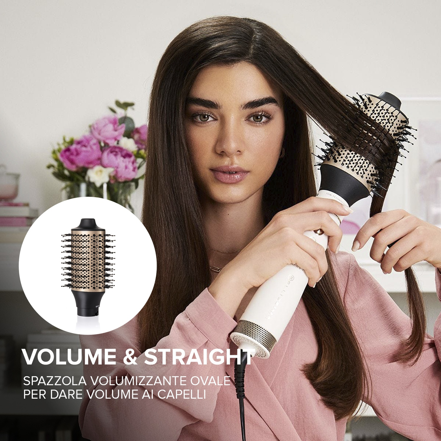 Donna che acconcia i capelli con una spazzola volumizzante. Tiene la spazzola bianca con setole nere. Fiori rosa sullo sfondo.