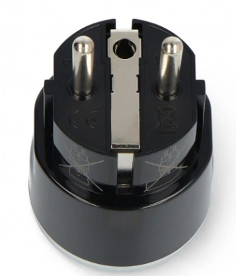 Czarny adapter wtyczki z dwoma srebrnymi pinami i metalowym klipsem uziemiającym. Podstawa jest błyszcząca i zaokrąglona.