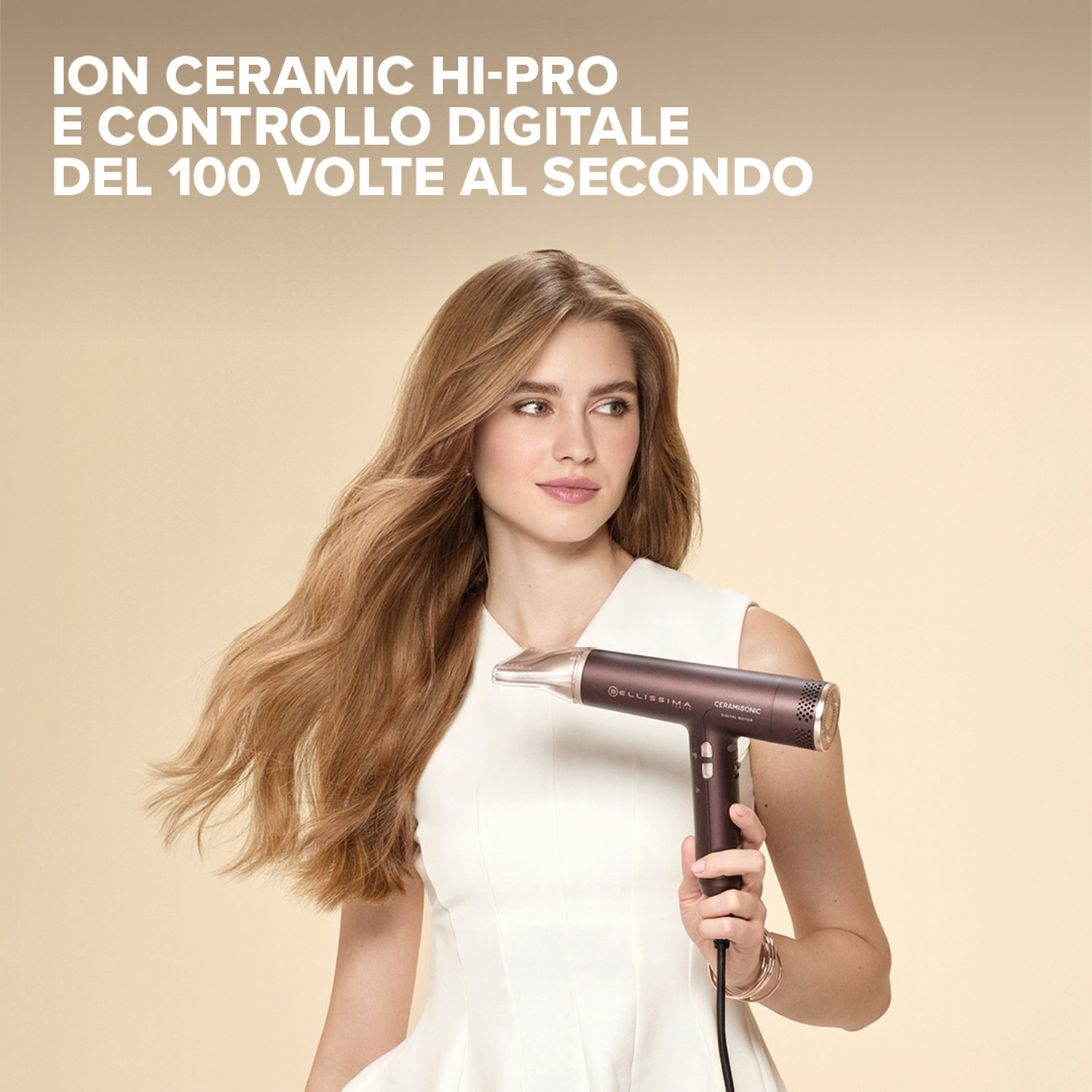 Una donna tiene un asciugacapelli scuro. Ha lunghi capelli castani e indossa un vestito bianco. Il testo in alto dice 'ION CERAMIC HI-PRO'.