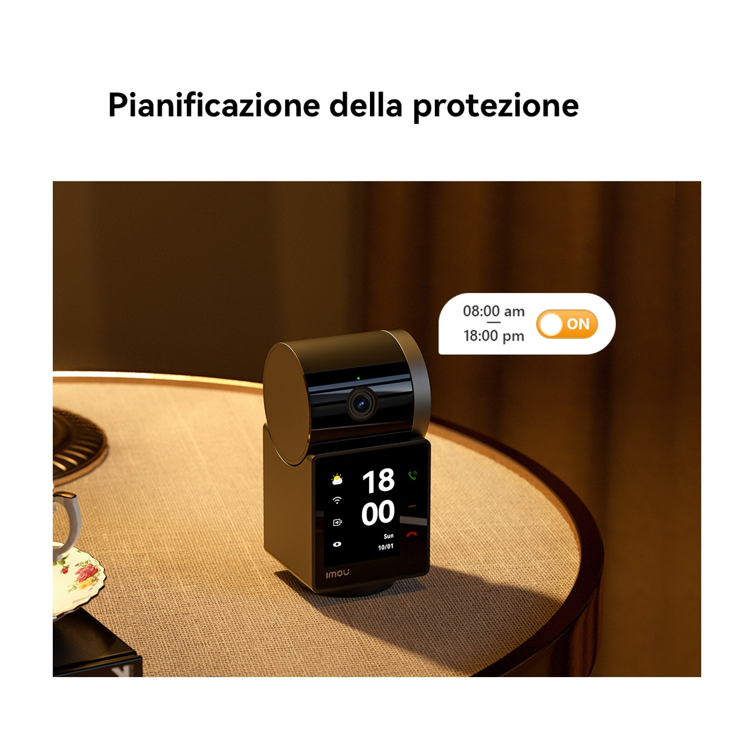 Una telecamera IMOU nera su un tavolo mostra le 18:00, con un pulsante ON. Una tazza da tè è a sinistra. Il testo in alto dice, P. della protezione.