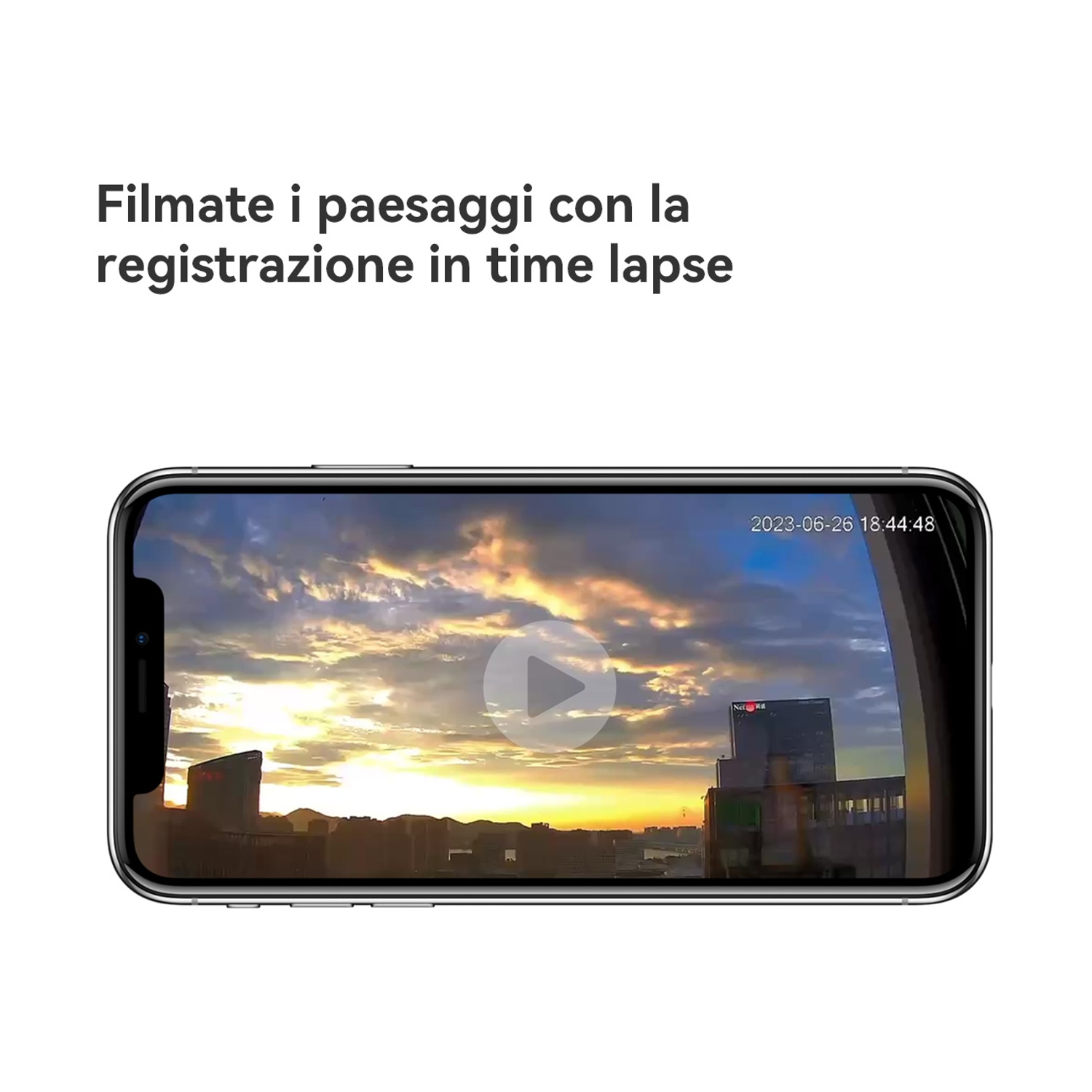 Telefono che mostra un video time-lapse del tramonto. Edifici in primo piano, con pulsante play sullo schermo. Il cielo è colorato.