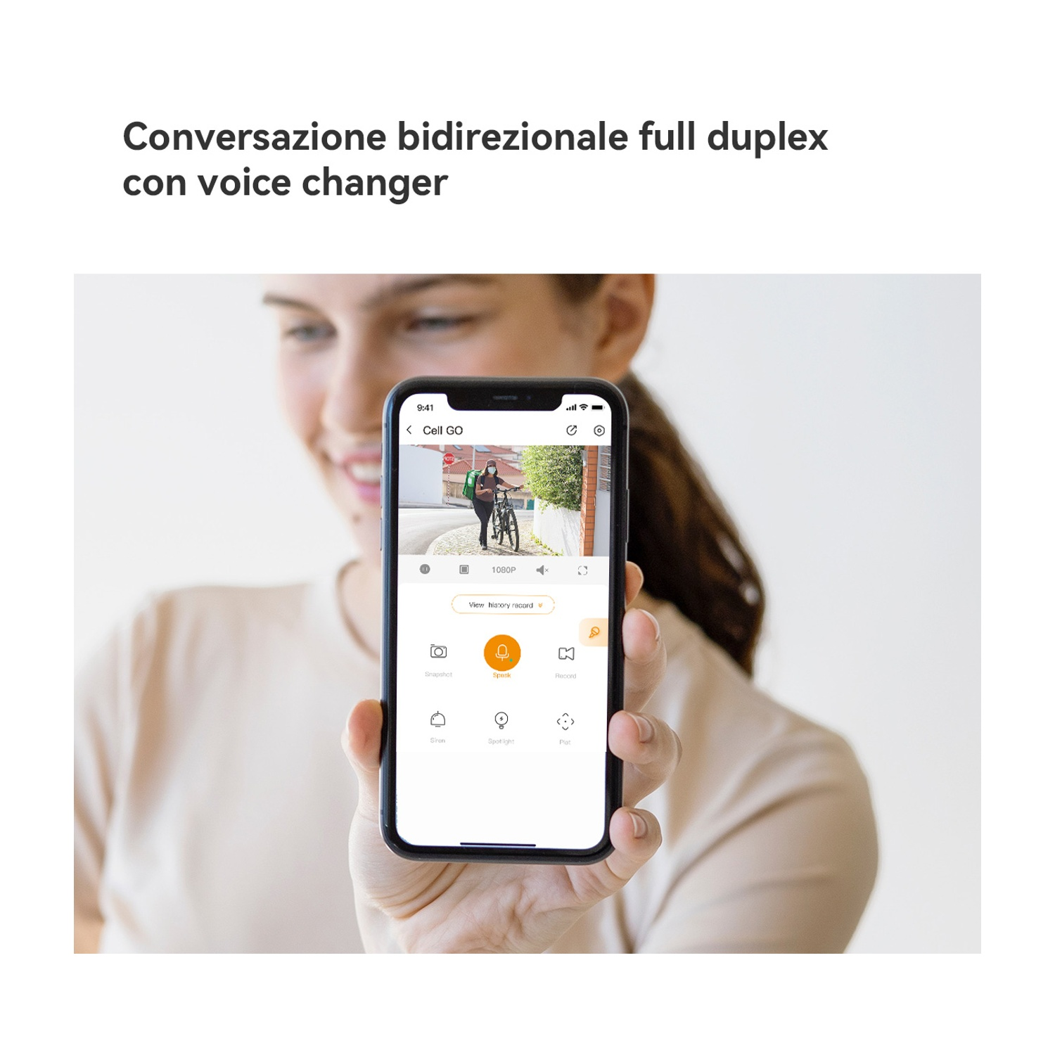 Una donna tiene in mano un telefono che mostra un feed video in diretta. Il feed mostra una persona in bicicletta. L'interfaccia del telefono include diverse icone di controllo.