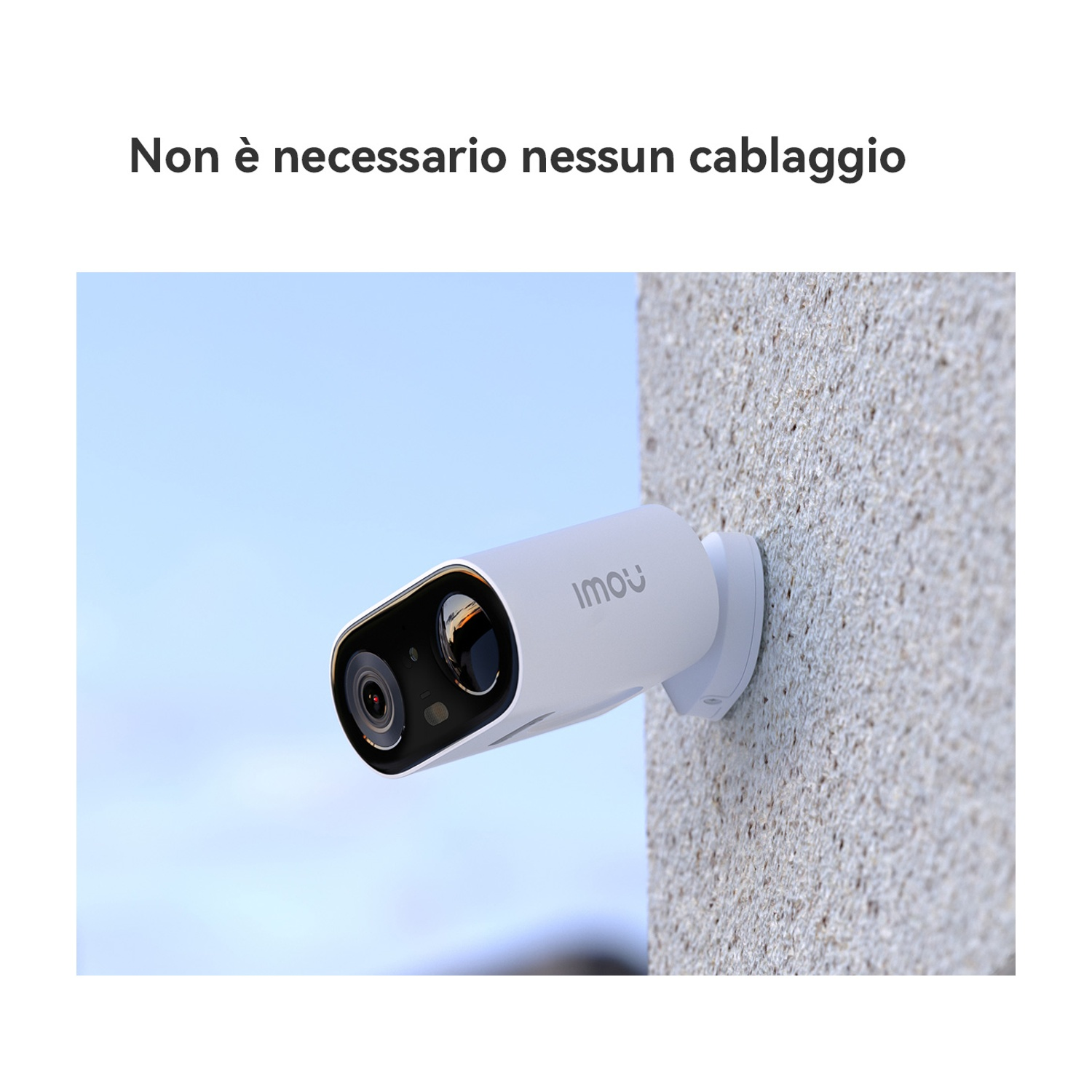 Una telecamera di sicurezza bianca con il logo 'Imou' è montata su un muro strutturato contro un cielo blu sfocato.