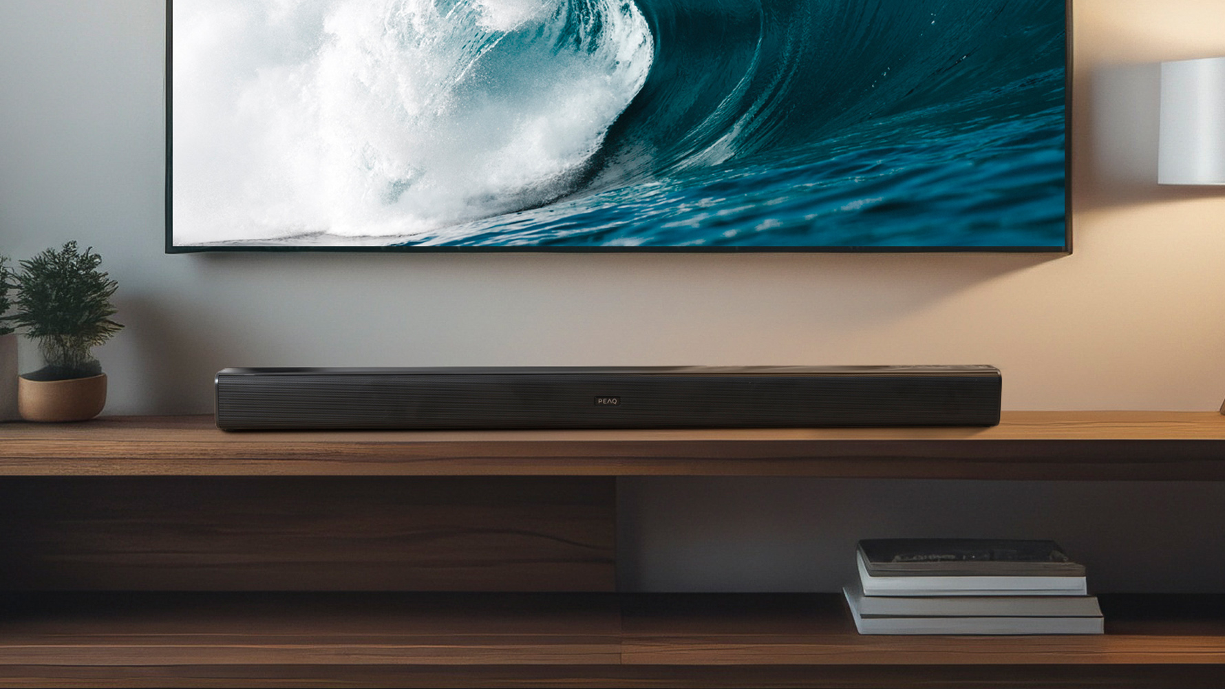 Ein Fernseher zeigt eine Welle. Eine Soundbar befindet sich darunter auf einem Holzregal. Eine kleine Pflanze und Bücher sind ebenfalls sichtbar.