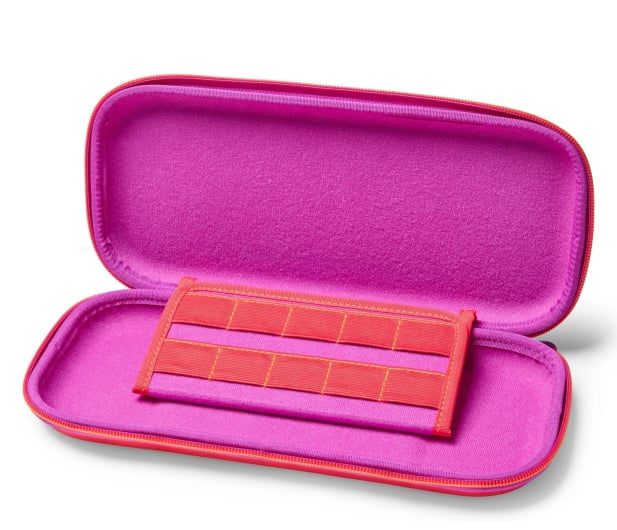 Otwarta różowa obudowa. W środku różowa wyściółka i czerwona przegroda z elastycznymi paskami. Obudowa jest na białym tle.