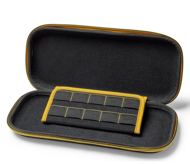 Otwarta czarno-żółta obudowa. W środku żółto-czarny organizer na kartridże do gier. Obudowa jest otwarta na białej powierzchni.