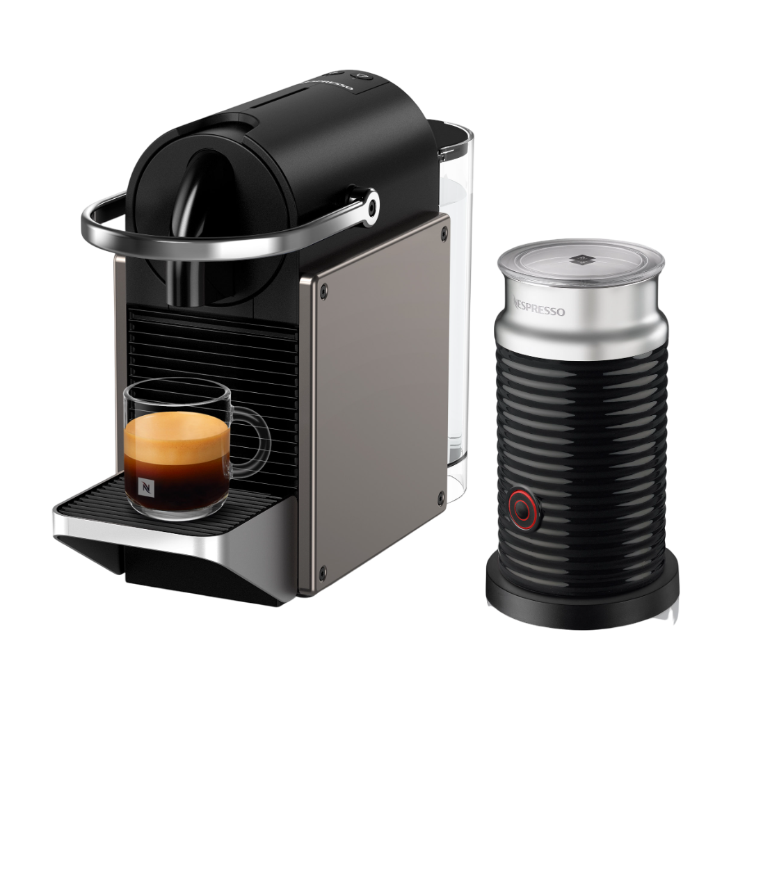 Siyah bir Nespresso makinesi, bir bardak kahve ve siyah bir yüzeyde bir süt köpürtücü. Makine gümüş ve siyahtır.