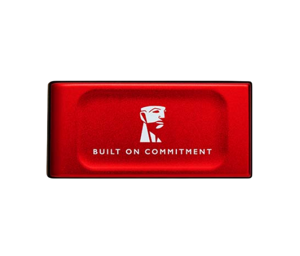 Siyah zemin üzerinde beyaz logo ve 'BUILT ON COMMITMENT' yazısı bulunan kırmızı dikdörtgen bir nesne.