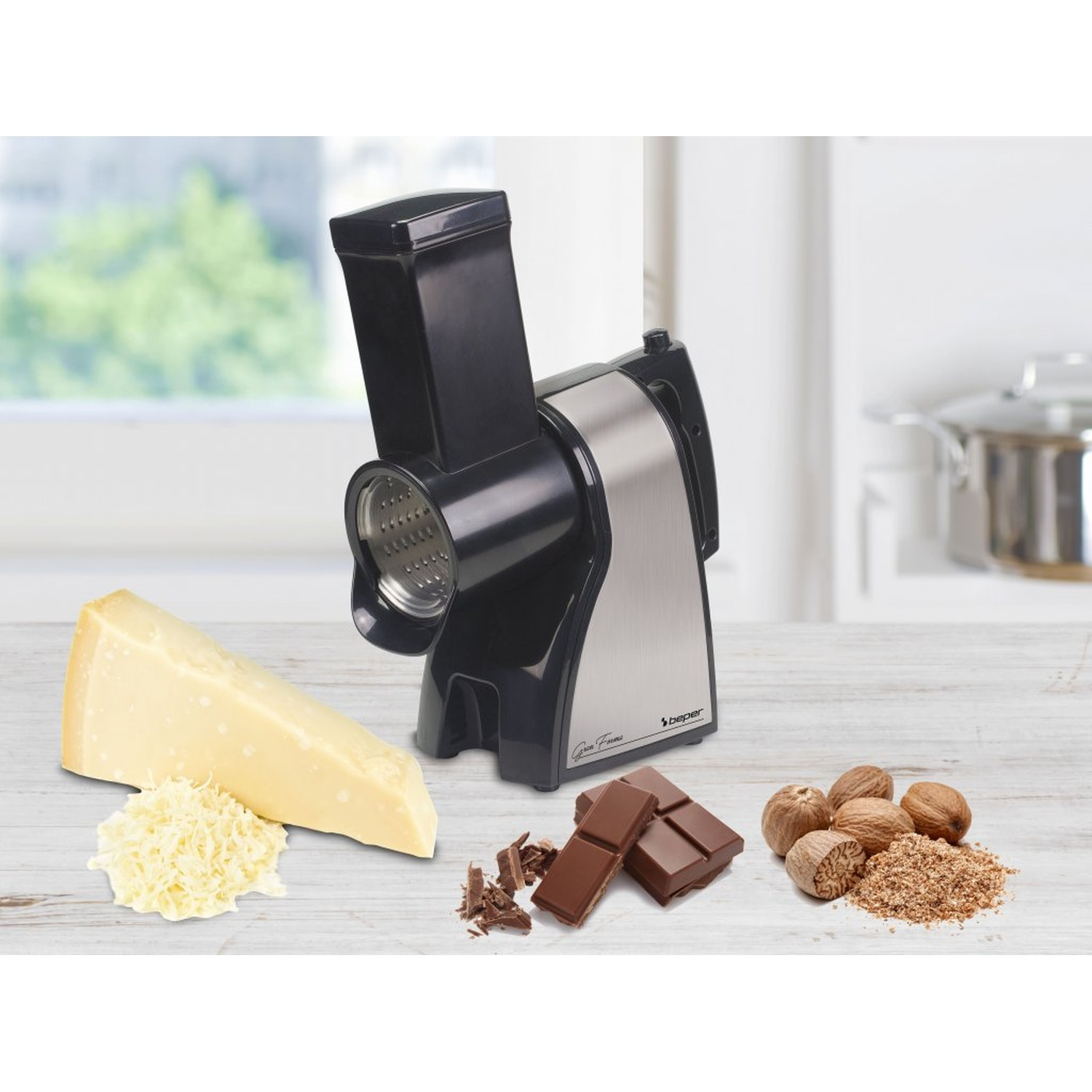 Elektrische rasp met kaas, chocolade en nootmuskaat. De achtergrond omvat een raam, een pot en een houten tafel.