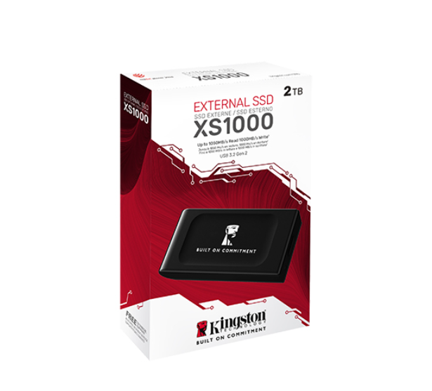 Görüntüde bir Kingston XS1000 harici SSD görülüyor. Kutu kırmızı ve beyazdır, SSD ön tarafta sergileniyor. 2 TB'lık bir sürücü.