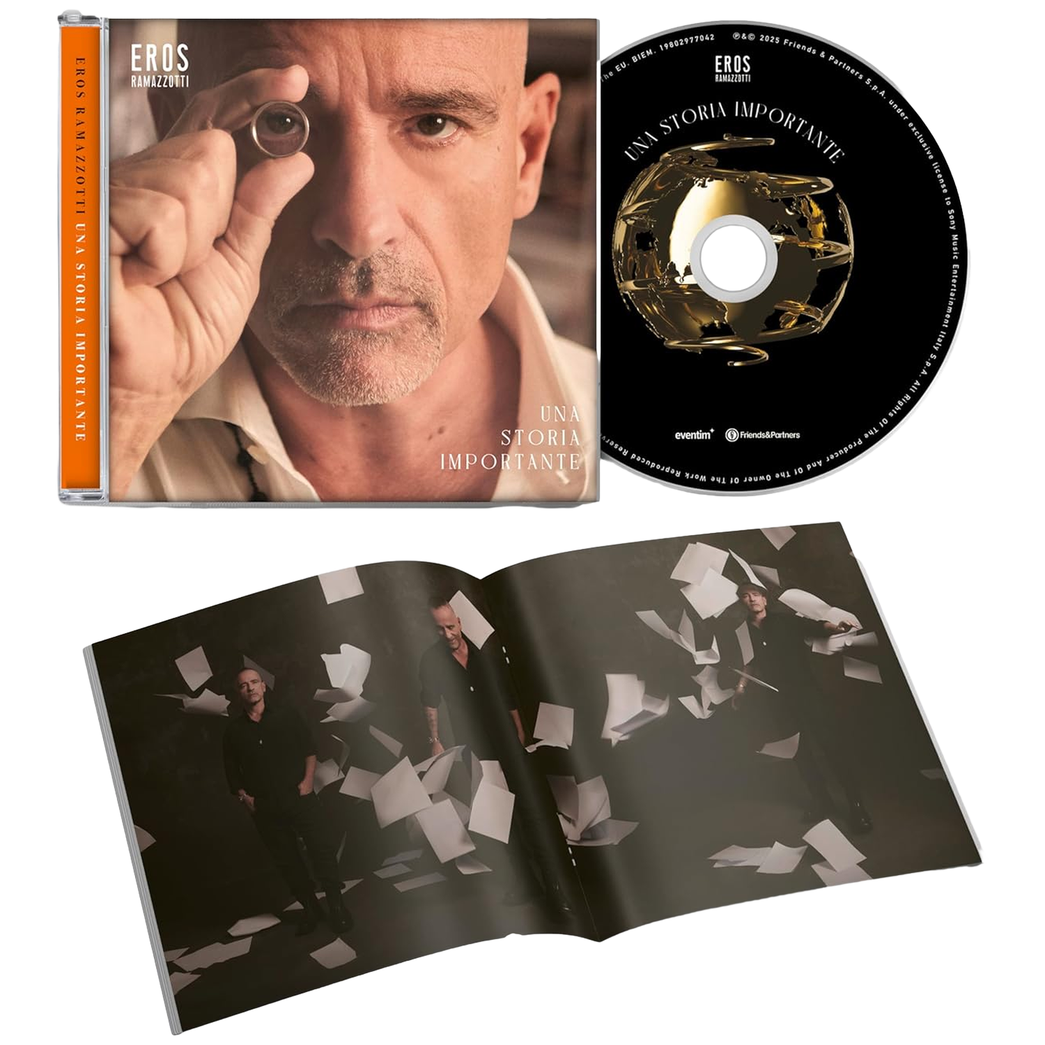CD et livret : album d'Eros Ramazzotti 'Una Storia Importante'. Homme tenant une bague devant l'œil. Livret avec des papiers qui tombent.