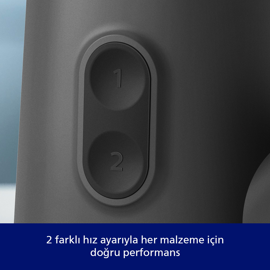 Gri bir cihazın yakın çekimi. '1' ve '2' etiketli iki siyah düğme görülüyor. Cihaz mavi bir arka plan üzerinde.