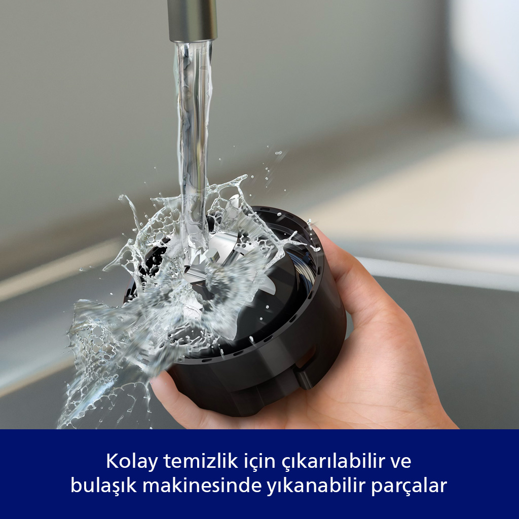 Bir el, siyah bir cihazı su akıntısının altında tutuyor. Su, cihazın etrafına sıçrayarak temizliği gösteriyor.