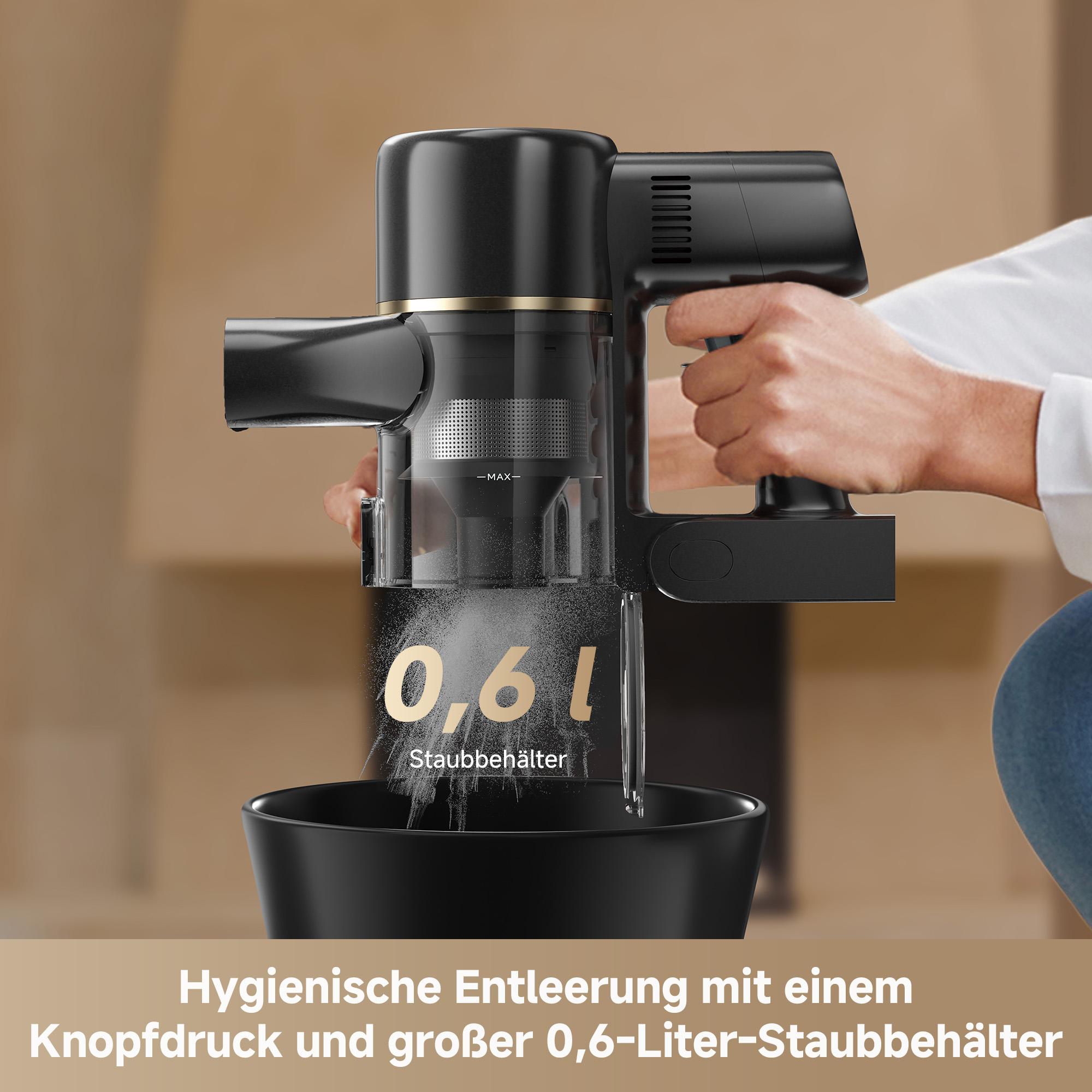 Ein schwarzer kabelloser Staubsauger wird gehalten. Er hat einen transparenten Staubbehälter mit 0,6 l Fassungsvermögen. Darunter eine schwarze Schüssel.