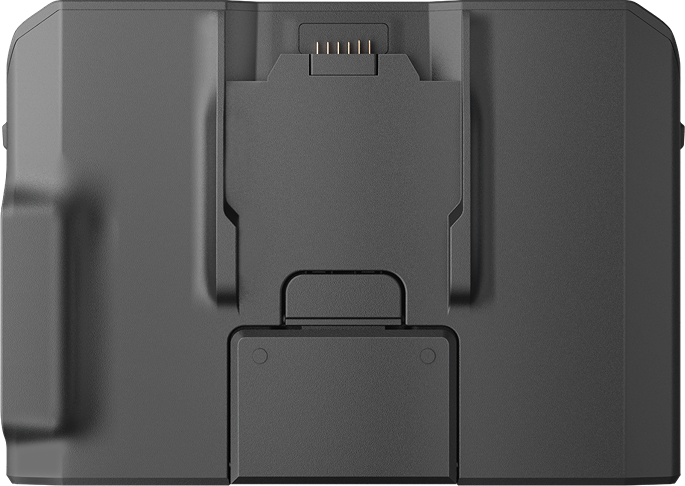 Un appareil rectangulaire gris foncé avec diverses sections encastrées, dont un port de charge et un petit panneau rectangulaire.