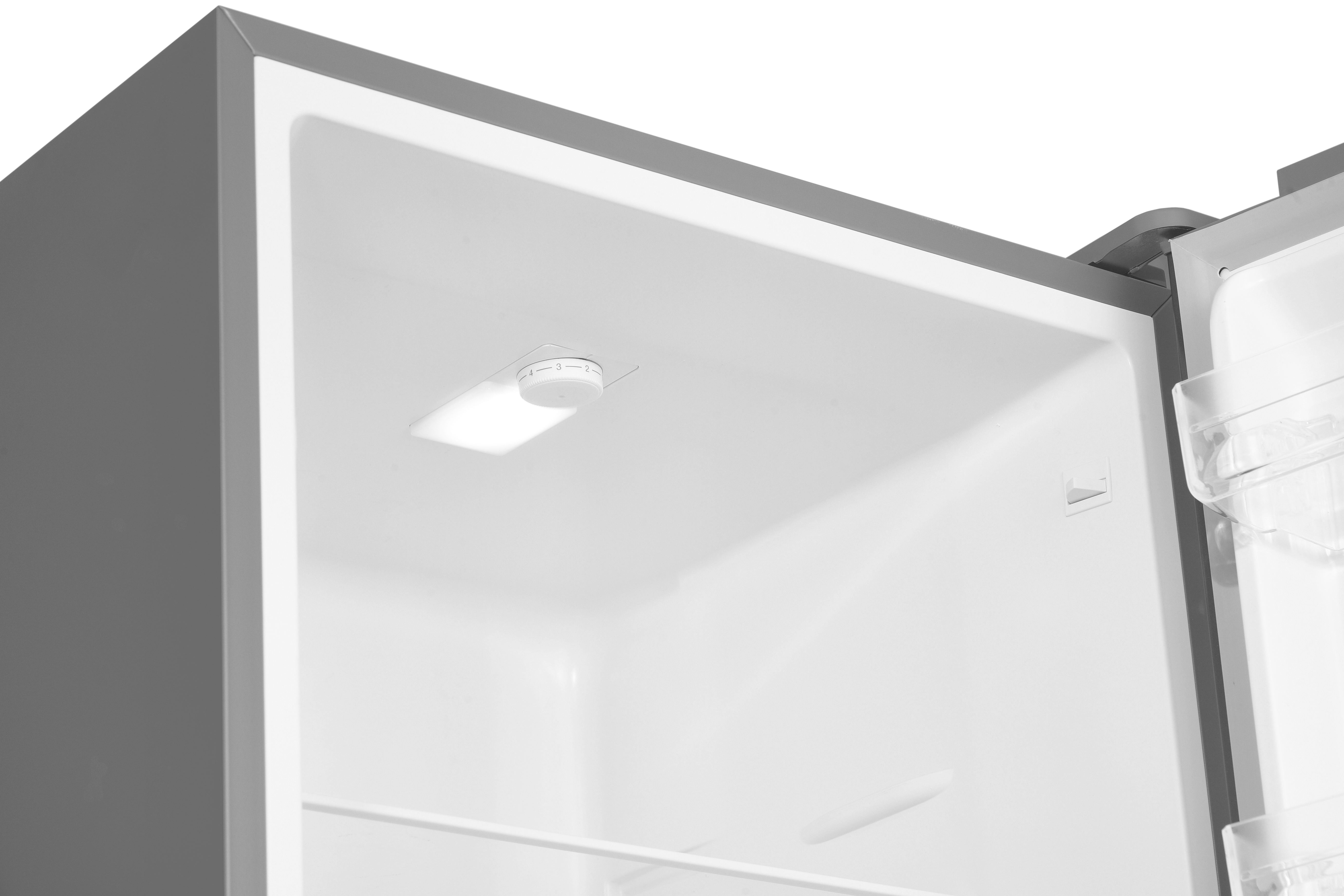 Inside a refrigerator, white interior. A light and a control knob are visible. The door is slightly ajar.