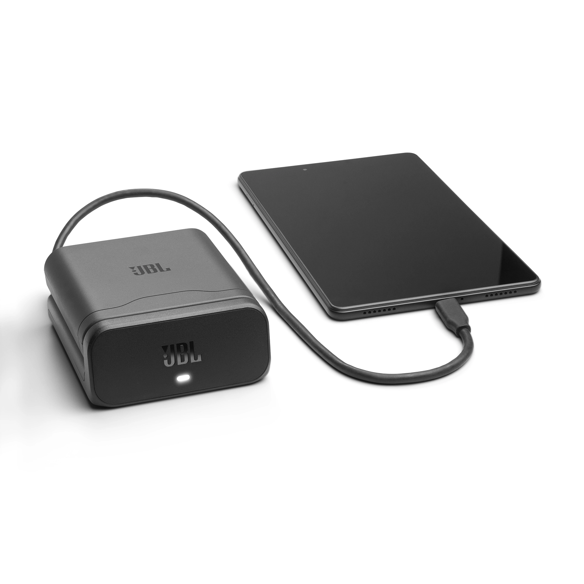 Ein schwarzer JBL-Powerbank ist mit einem schwarzen Tablet mit einem Ladekabel auf weißem Hintergrund verbunden.
