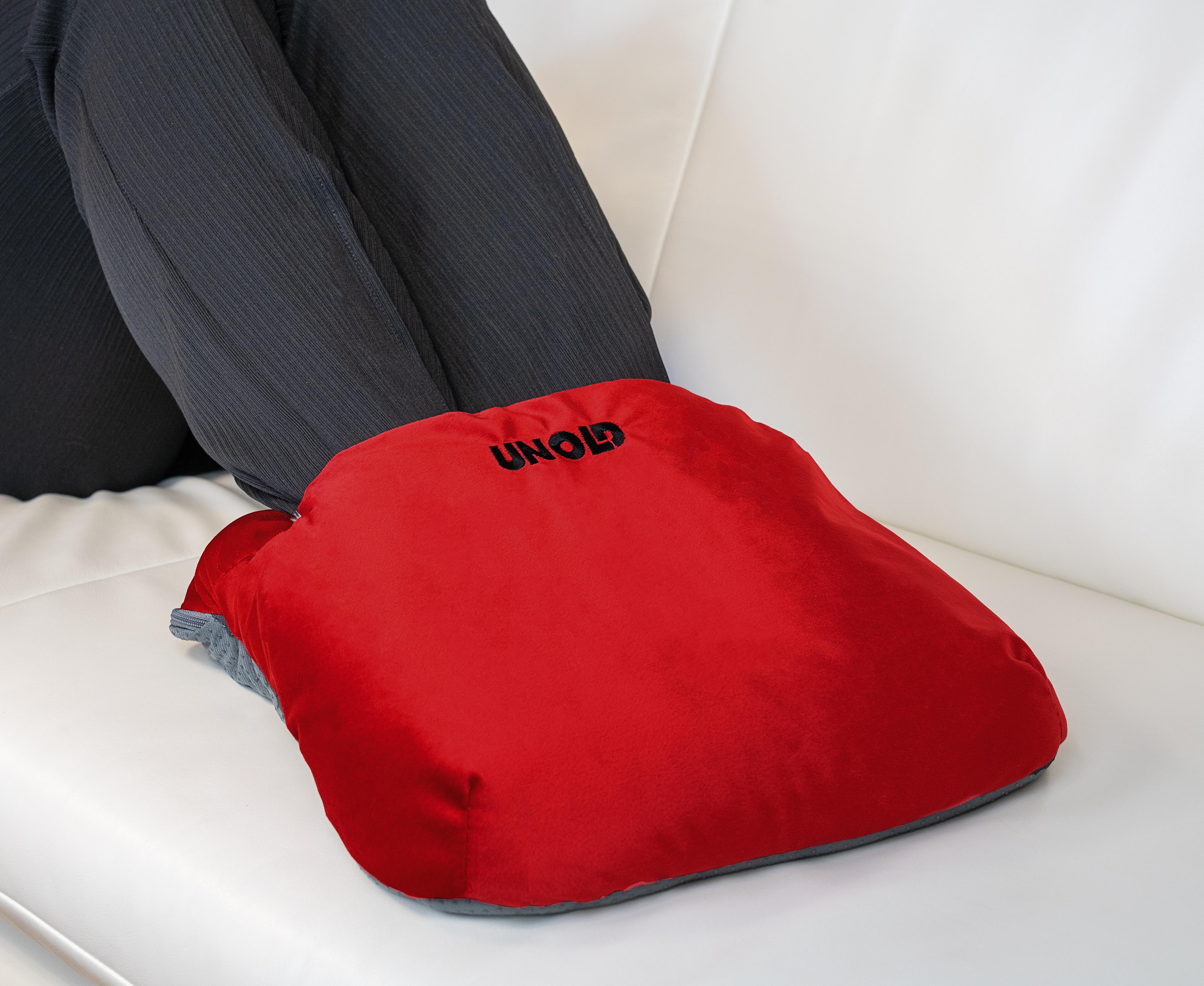 Beine einer Person auf weißem Sofa, ruhend auf einem roten Fußwärmer mit 'UNOLD' Text.