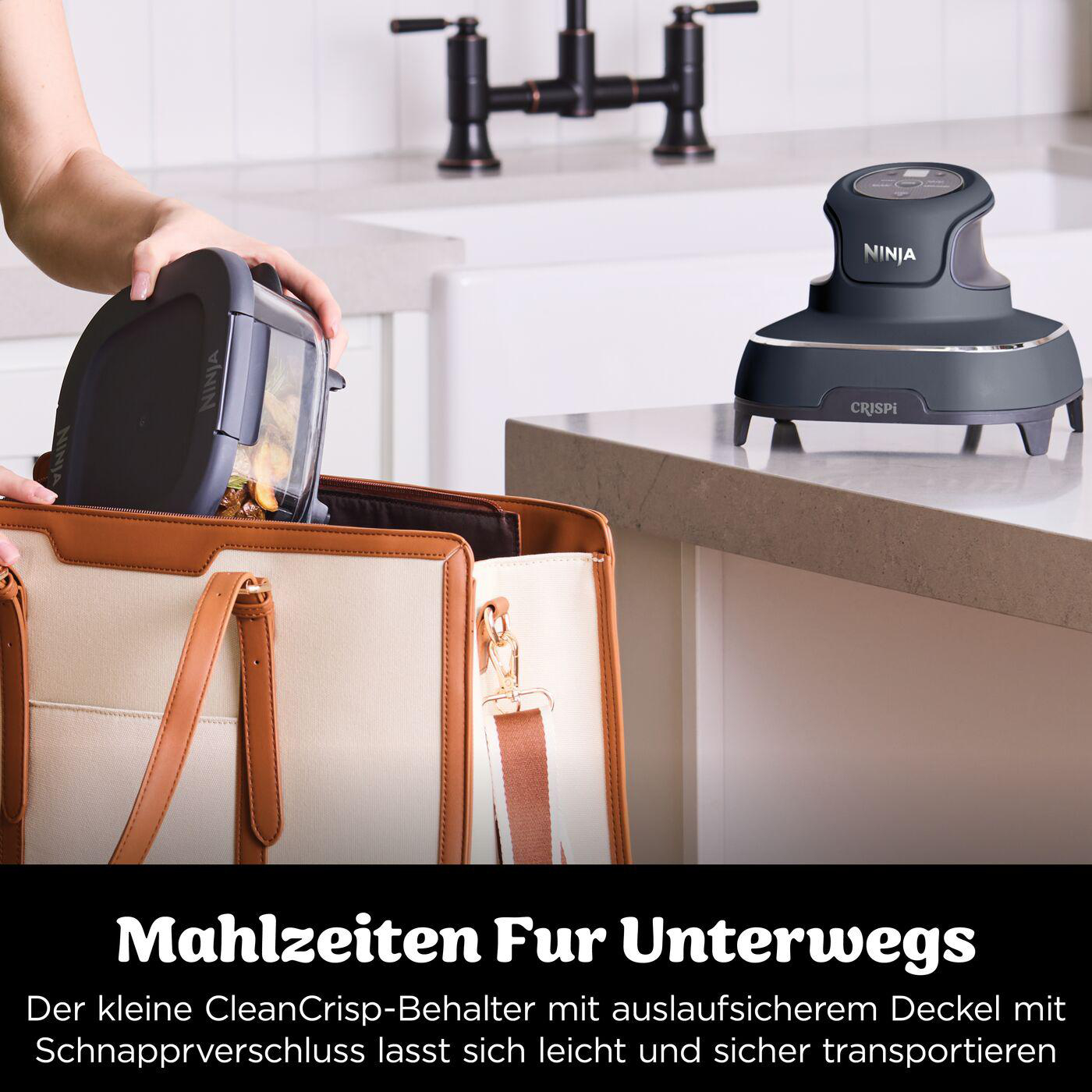 Eine Person legt einen Ninja-Behälter in eine Tasche. Auf einer Theke steht eine Crispi-Maschine. Text sagt: "Mahlzeiten für unterwegs."