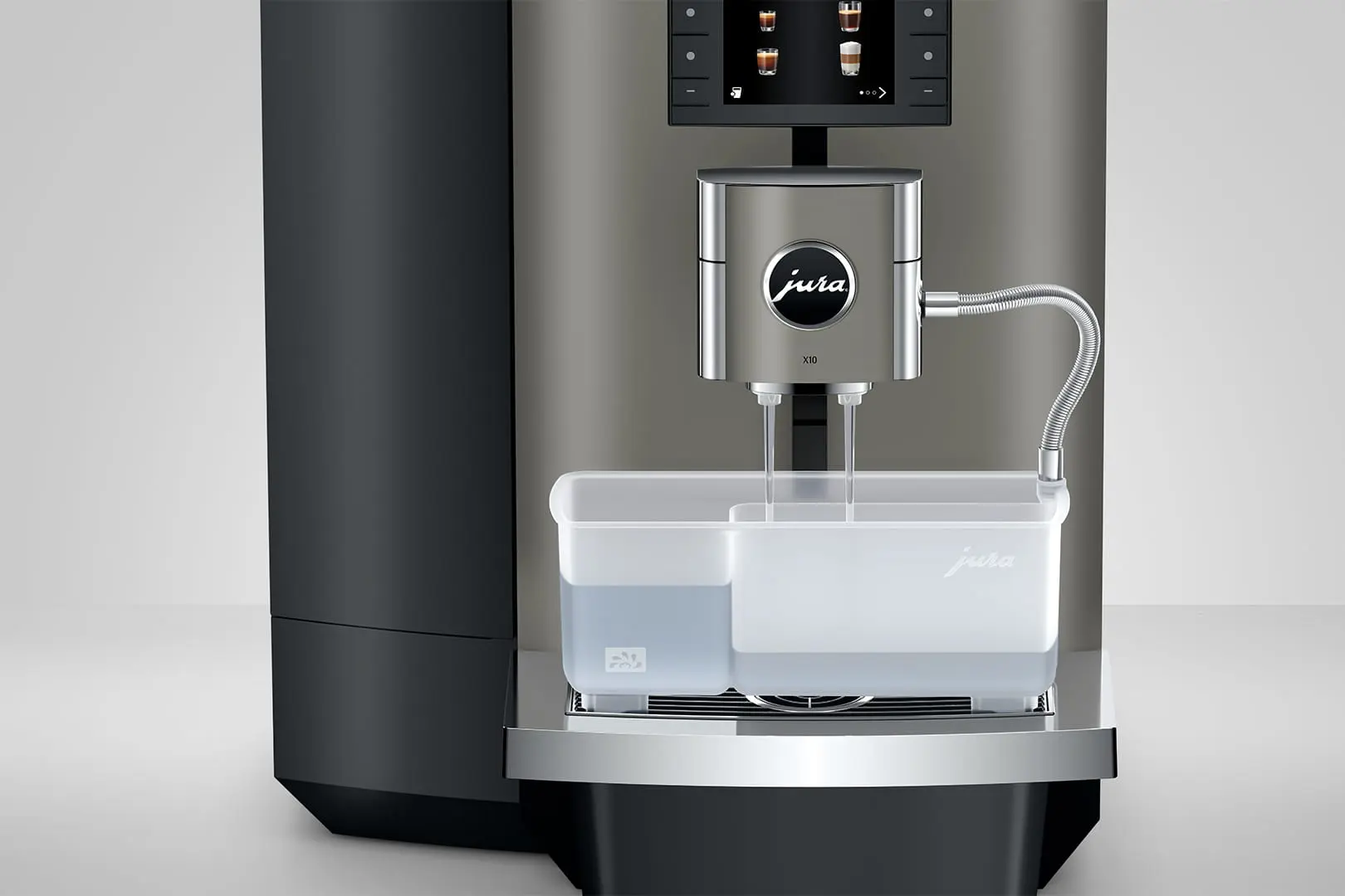 Una macchina da caffè Jura X10 argentata con serbatoio dell'acqua. La macchina è su una superficie bianca con sfondo grigio.