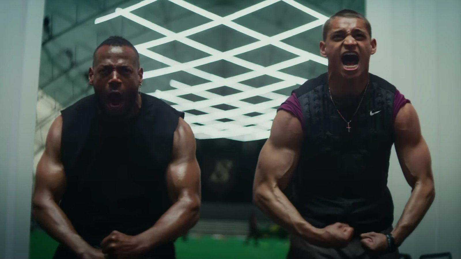 Zwei muskulöse Männer, die sich im Fitnessstudio biegen und schreien. Einer links, einer rechts. Hintergrund ist ein Lichtgitter.