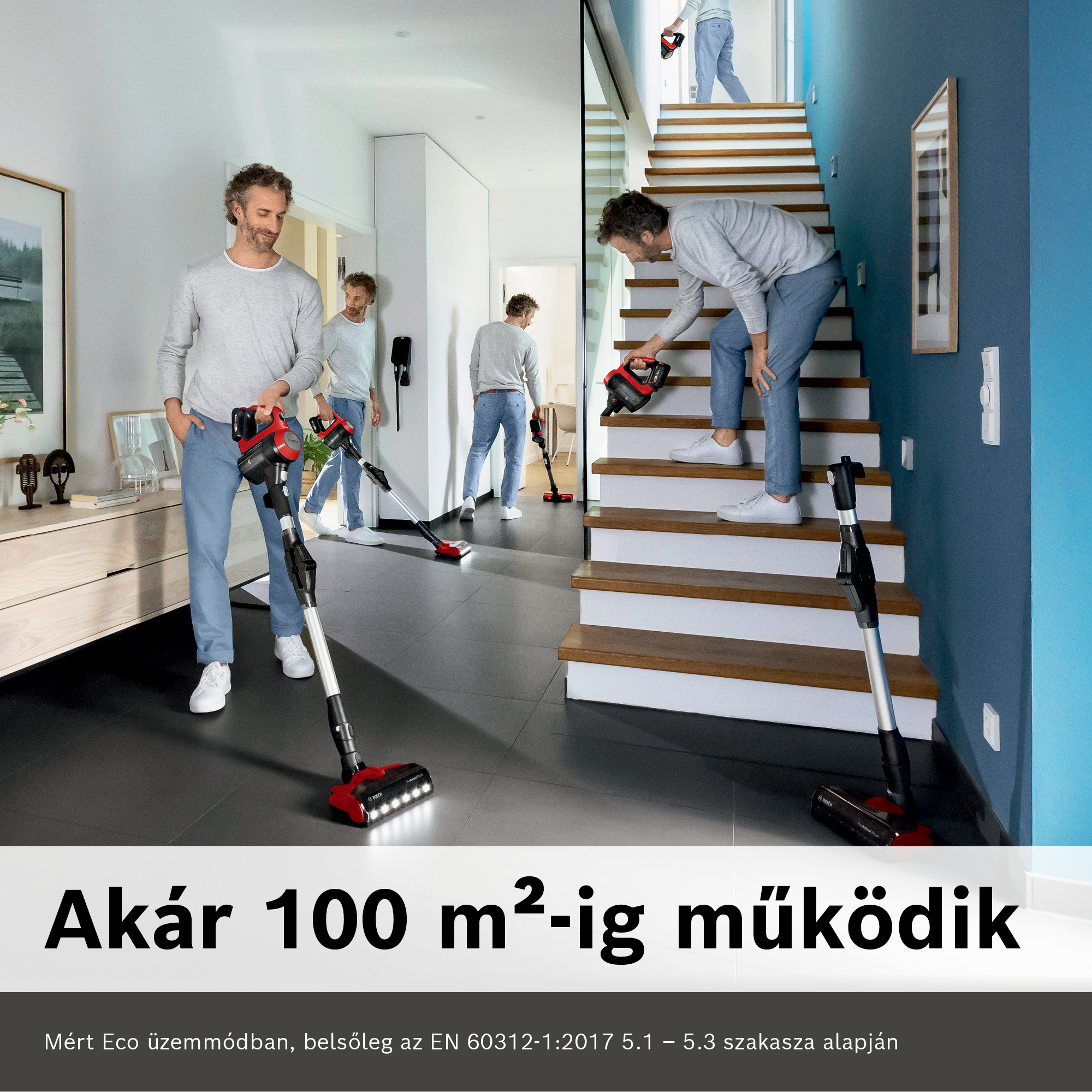 Egy férfi porszívózik egy szobában. Egy másik férfi a lépcsőn van egy hasonló készülékkel. A porszívó piros és fekete.