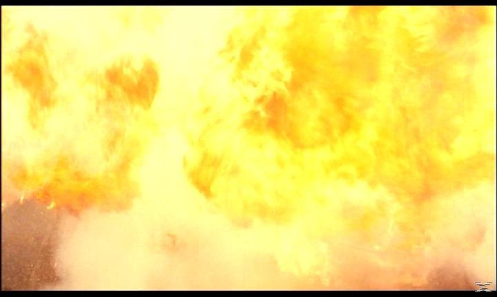 Das Bild zeigt eine große Explosion mit intensiven gelben und orangen Flammen. Rauch und Trümmer sind sichtbar, was auf eine gewaltige Detonation hindeutet.