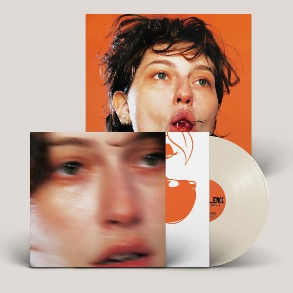 Albumcover: Frau mit Kirsche im Mund, auf orangefarbenem Hintergrund. Vinylplatte daneben. Ein weiteres Albumcover mit verschwommenem Gesicht.