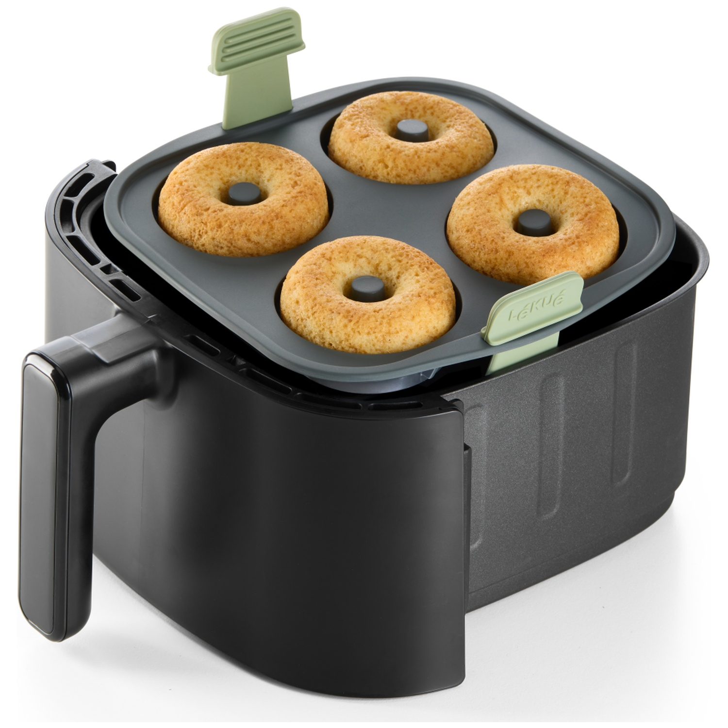 An air fryer with four donuts inside. The fryer is black with green accents. The donuts are golden brown.