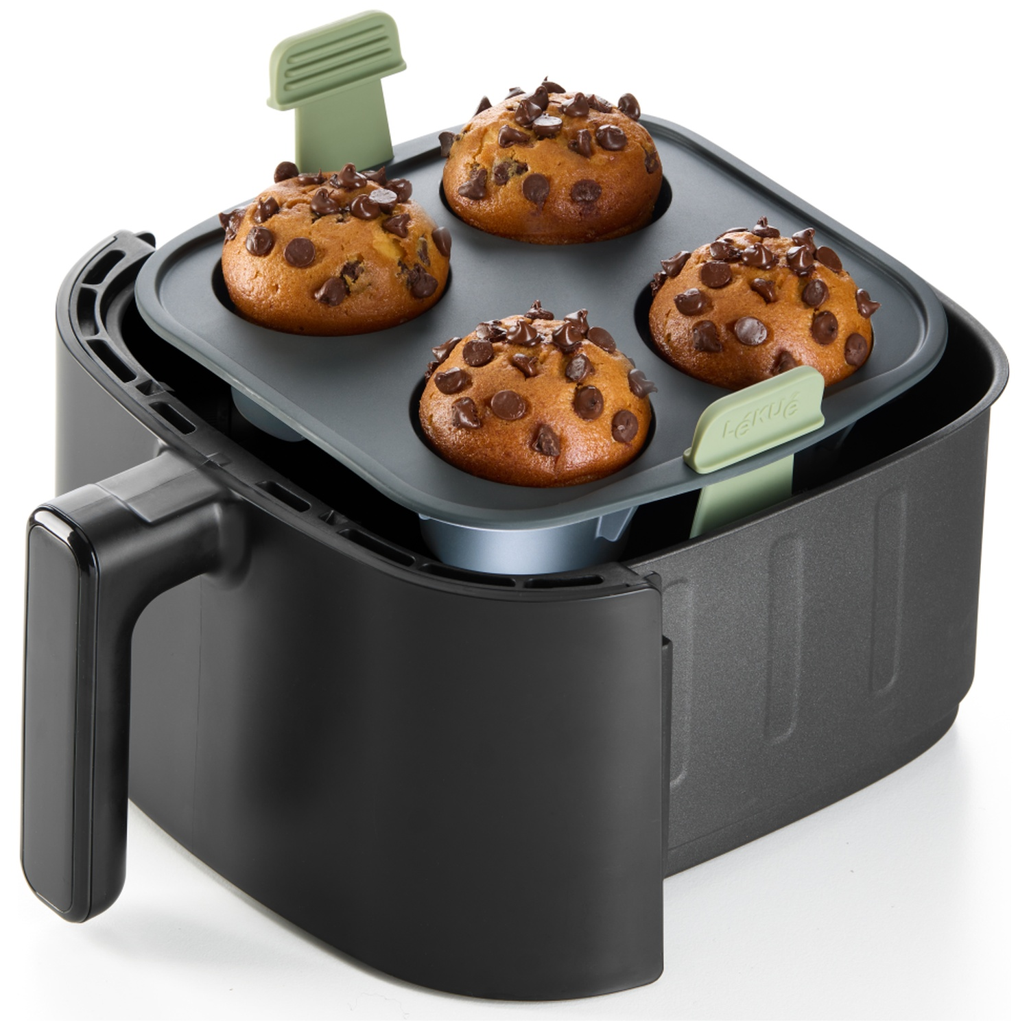 Un air fryer avec quatre muffins garnis de pépites de chocolat. L'air fryer est noir, les muffins sont dans un plateau gris.