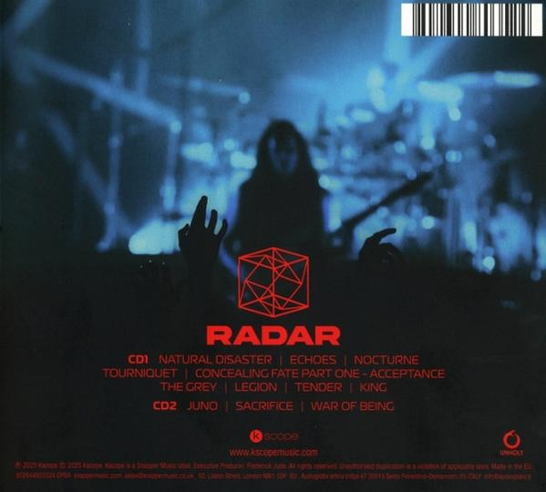Albumcover. Silhouetten von Bandmitgliedern auf der Bühne. Rotes geometrisches Logo. Songtitel und Text sind unten sichtbar.