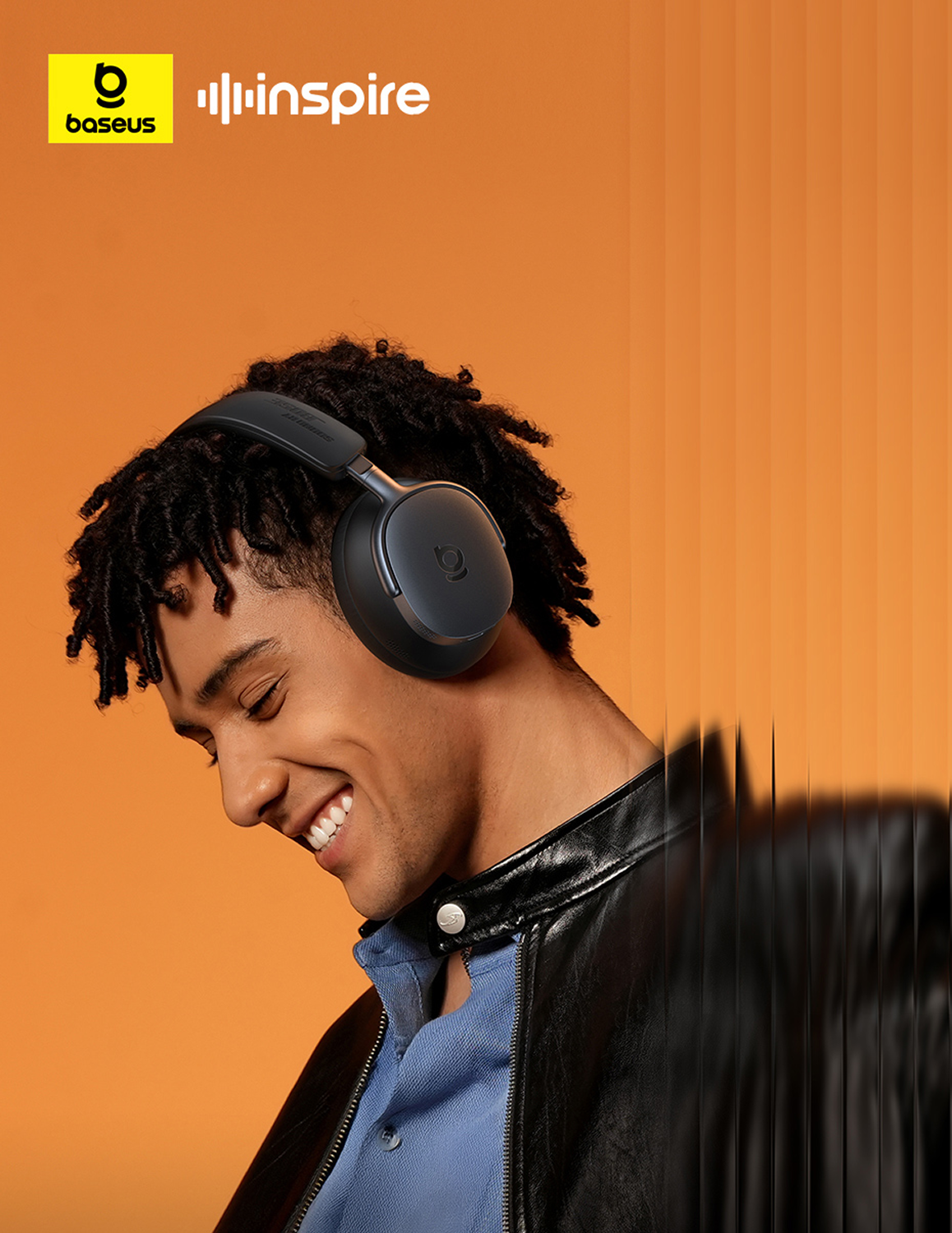 Un hombre sonriente con auriculares negros. Tiene rastas, una camisa azul y una chaqueta de cuero negra sobre un fondo naranja.