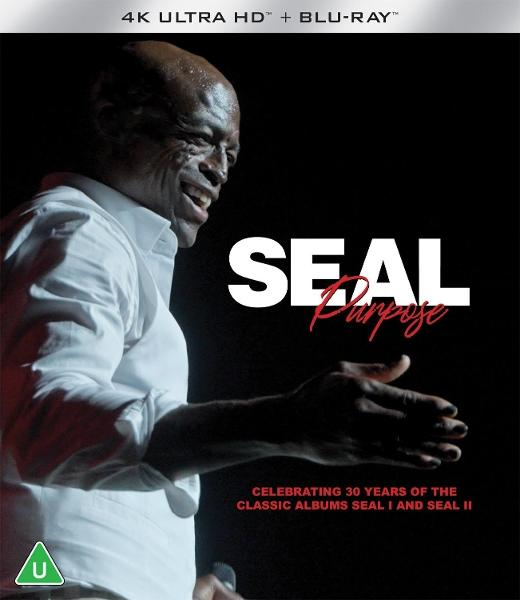 Seal auf der Bühne, lächelnd. Weißes Hemd, schwarzer Hintergrund. Text 'Seal Purpose', feiert 30 Jahre der Alben Seal I & II. 4K Ultra HD Blu-ray.