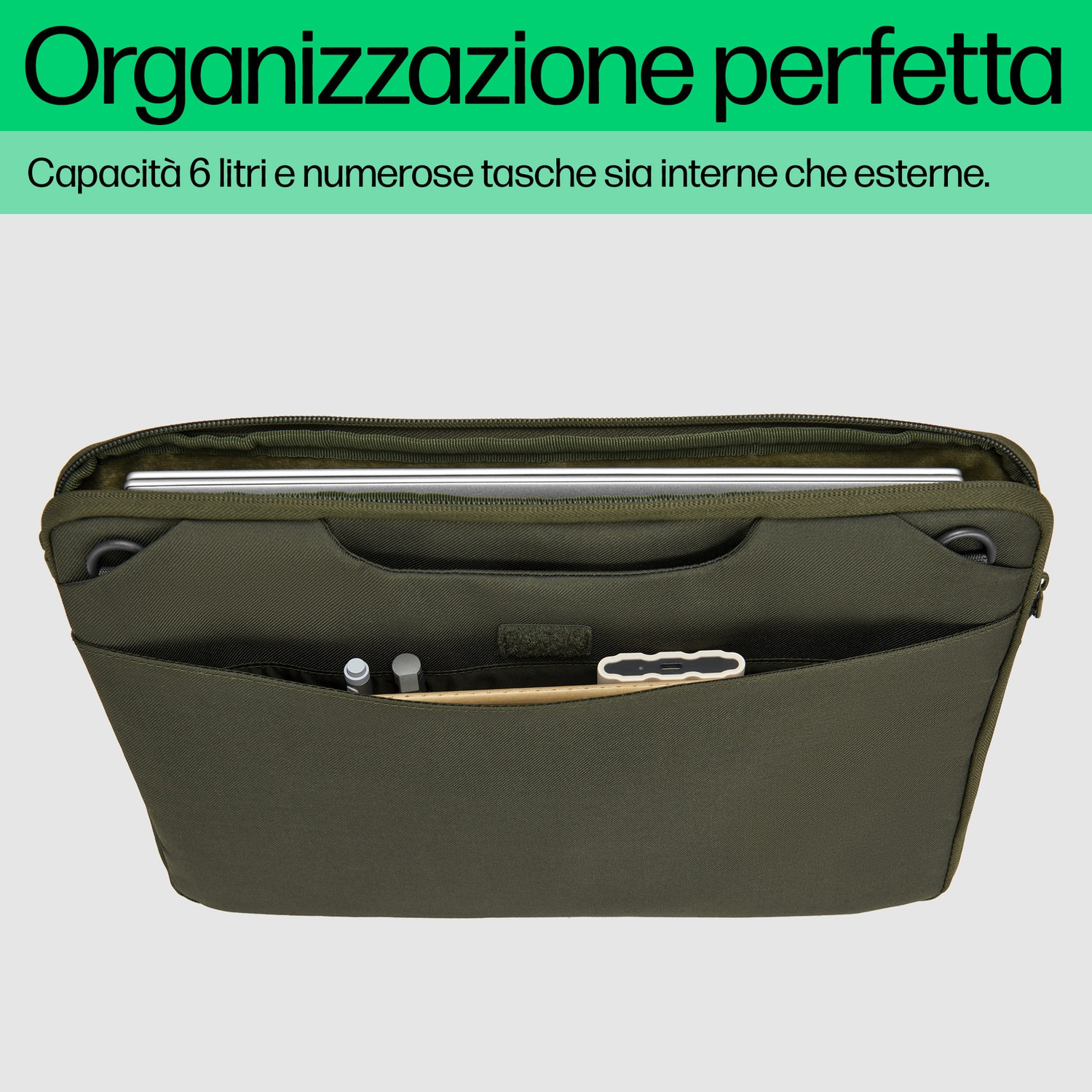 Una borsa verde aperta con tasche, contenente un laptop, penne e altri oggetti. La borsa è su sfondo bianco.