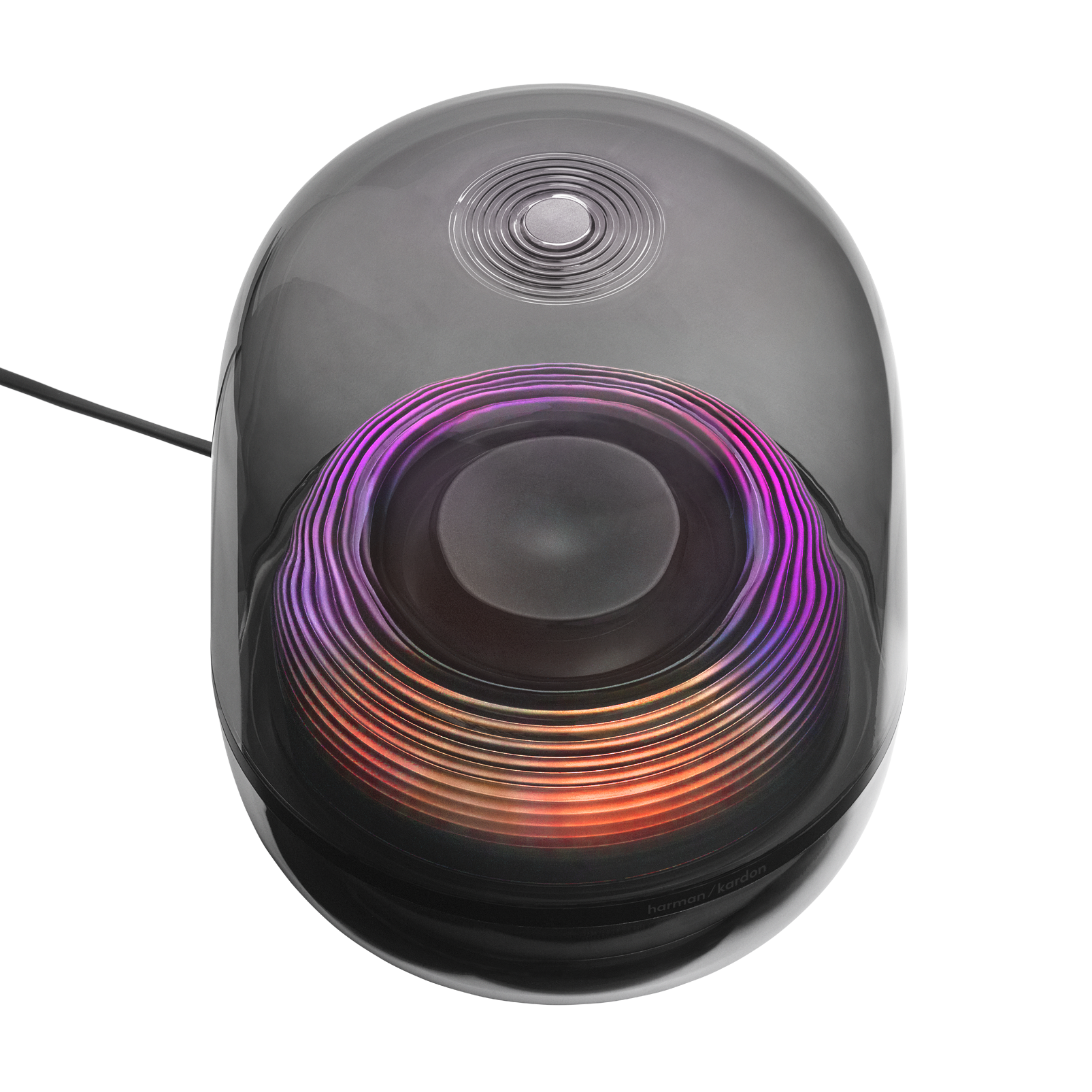 Renkli, dairesel bir ışık desenine sahip koyu renkli bir hoparlör. Üstünde bir düğme ve 'harman/kardon' logosu var.