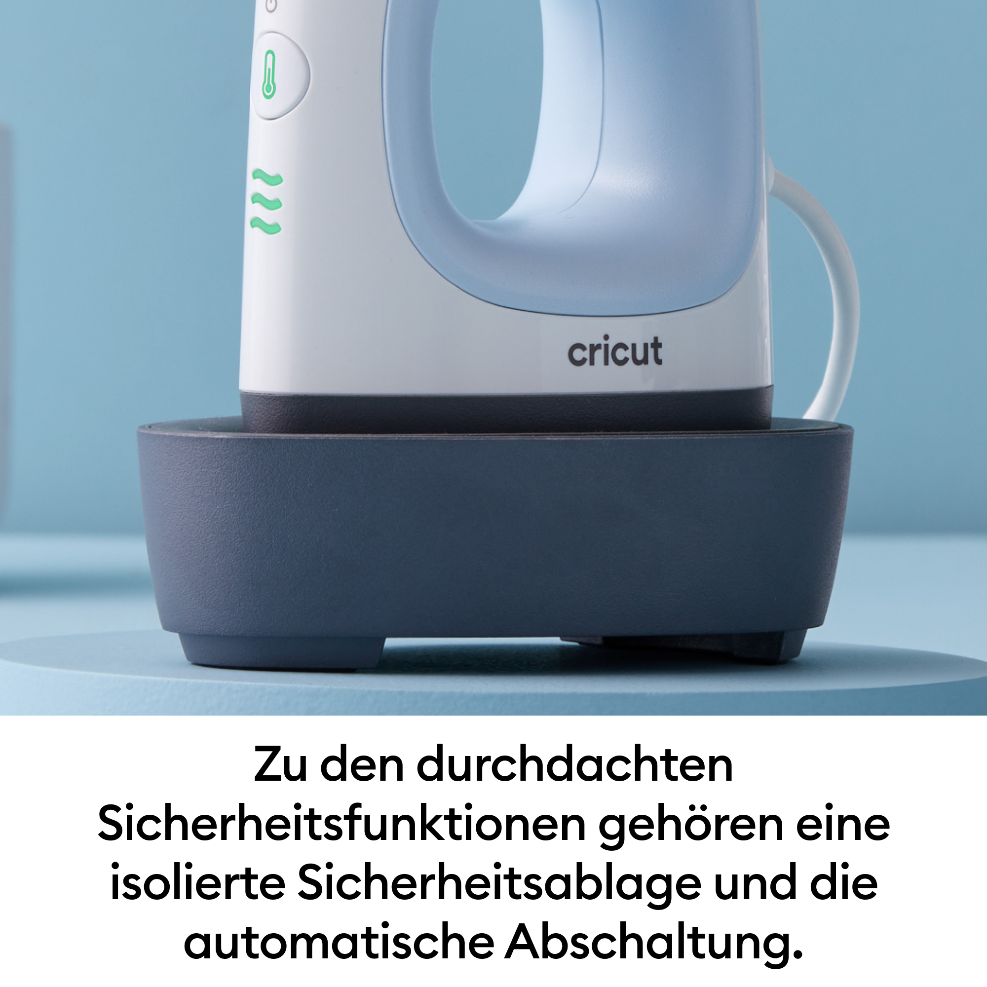 Ein weißes und blaues Cricut-Bügeleisen mit Griff, auf einer dunkelgrauen Basis, vor blauem Hintergrund.