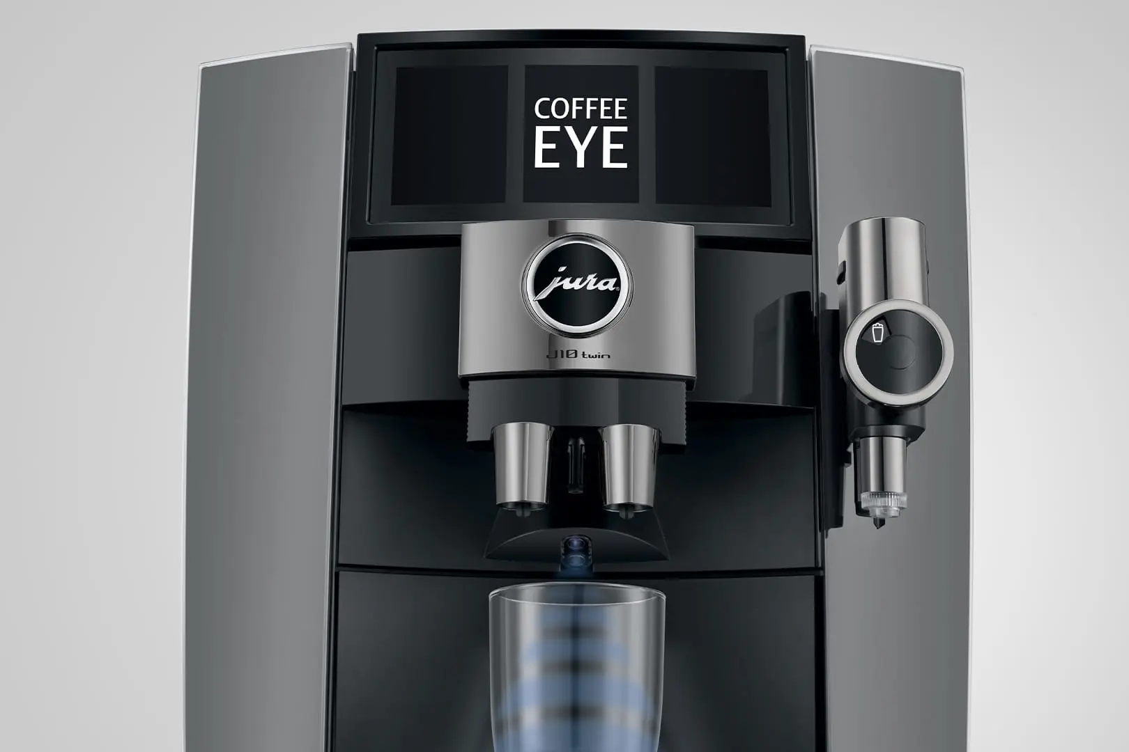 Eine moderne silber-schwarze Kaffeemaschine mit dem Wort 'COFFEE EYE' auf dem Display, ein Glas unter dem Ausguss.