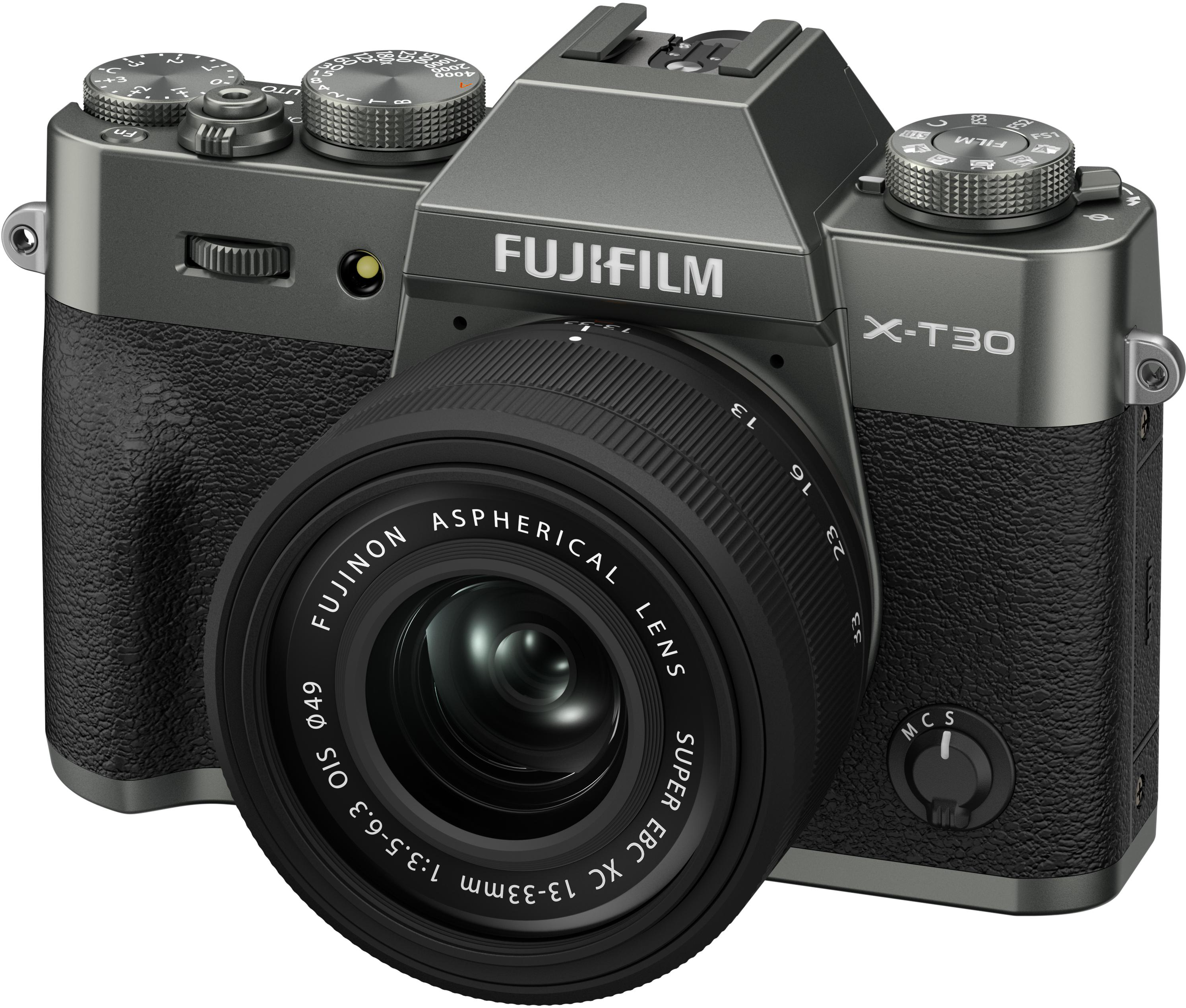Eine graue Fujifilm X-T30-Kamera mit Objektiv. Das Objektiv ist schwarz. Verschiedene Räder und Knöpfe sind sichtbar.