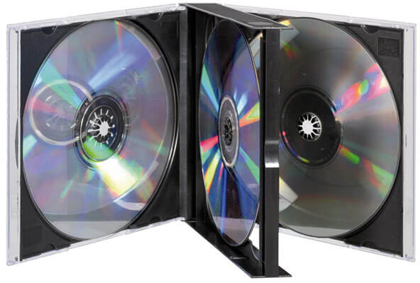 Offene CD-Hülle mit drei CDs. Zwei CDs befinden sich in den Hüllen, eine in der Mitte. Auf den CDs sind Farbreflexe zu sehen.