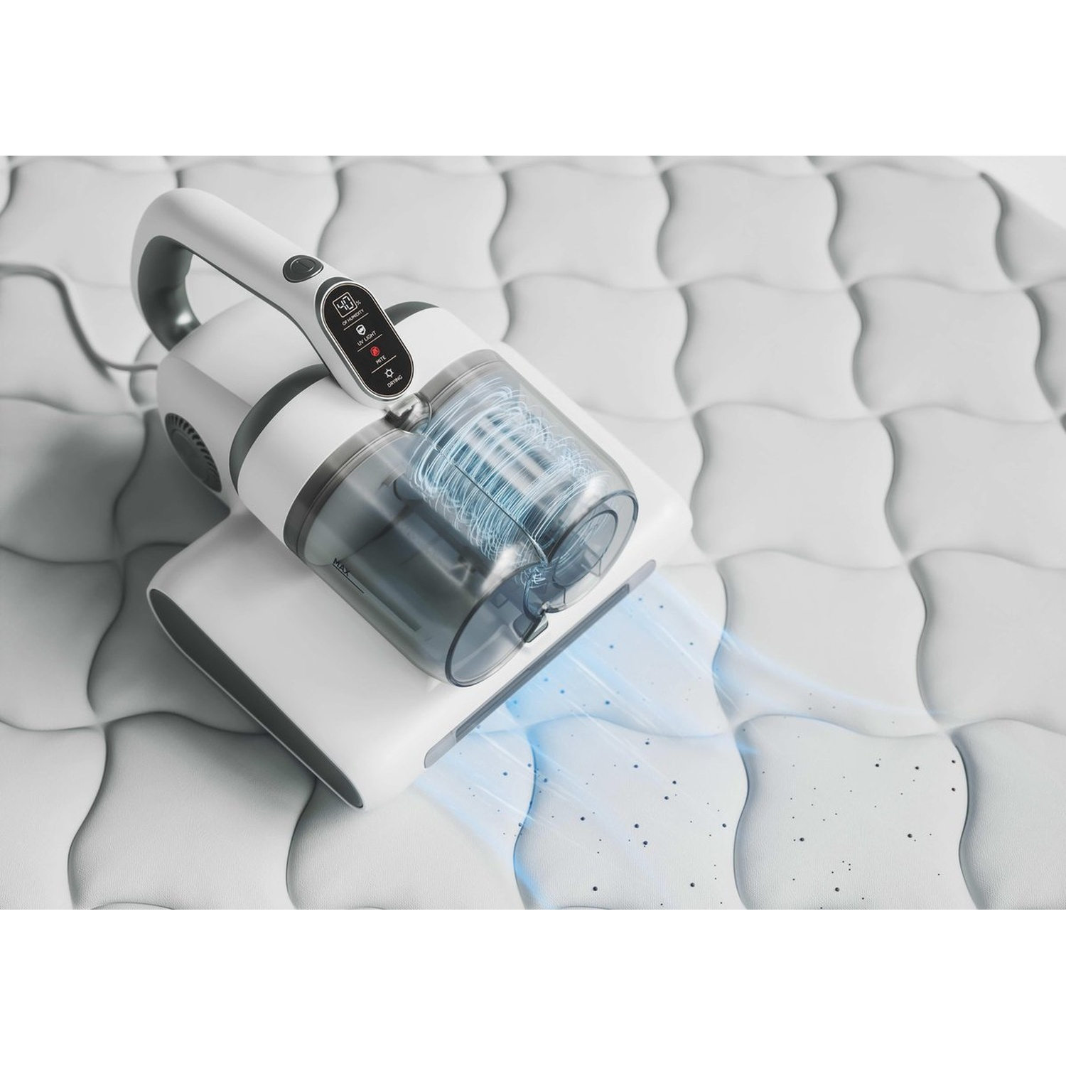 A white and gray handheld vacuum cleaner is cleaning a white quilted surface. Dust particles are visible being sucked up.