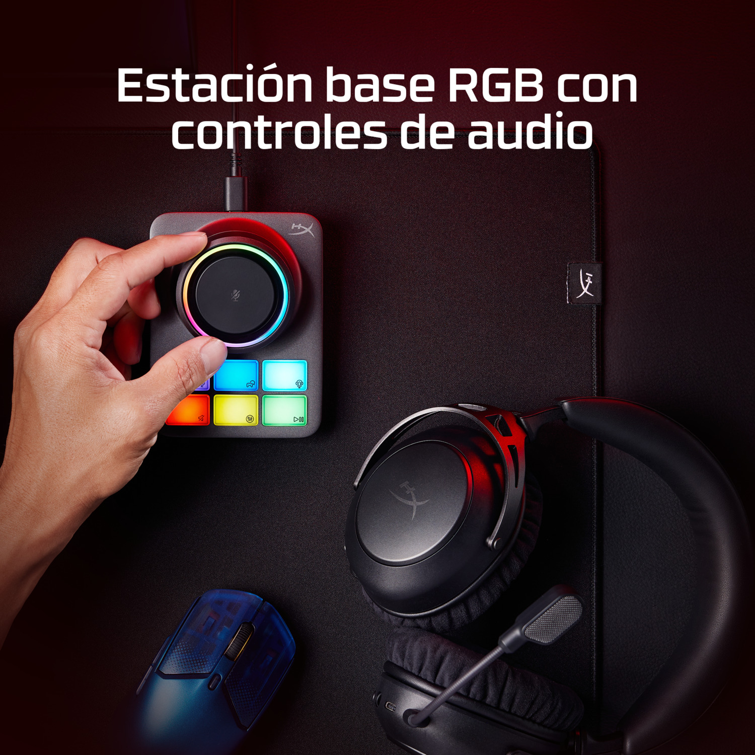 Mano ajustando una base de control de audio RGB con auriculares, ratón y almohadilla. Fondo negro.
