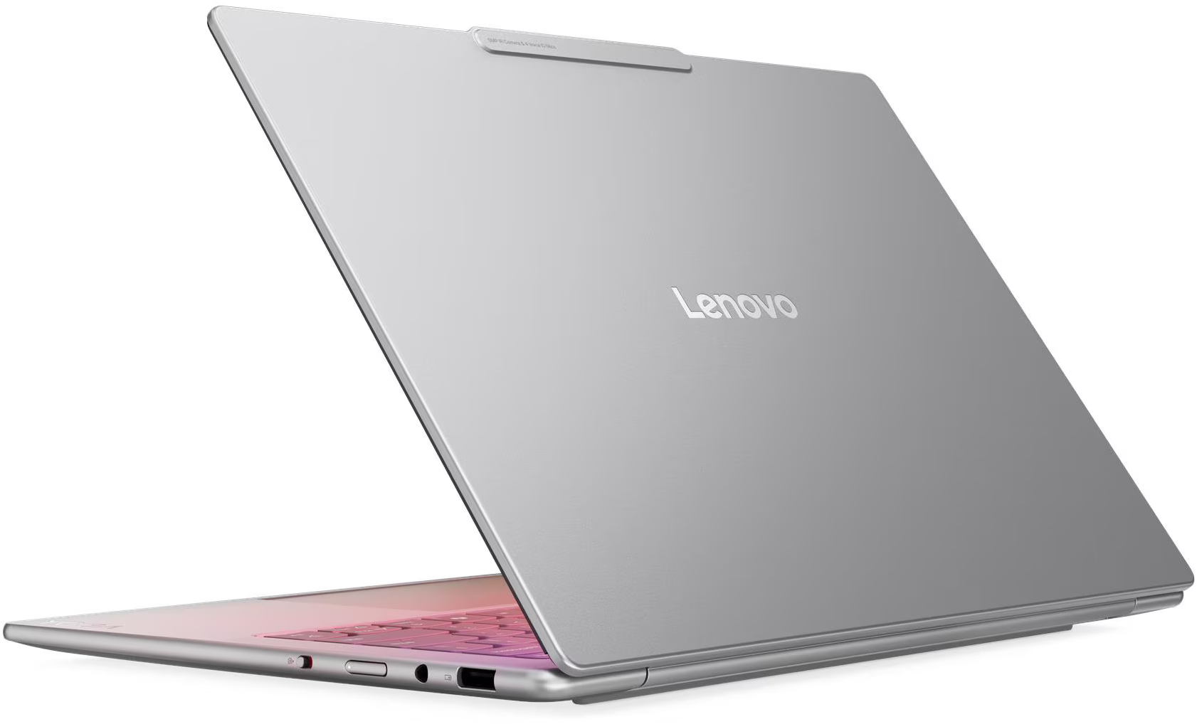 Ezüst Lenovo laptop részben nyitva, rózsaszín háttérvilágítású billentyűzetet mutat. A Lenovo logója látható a fedélen.