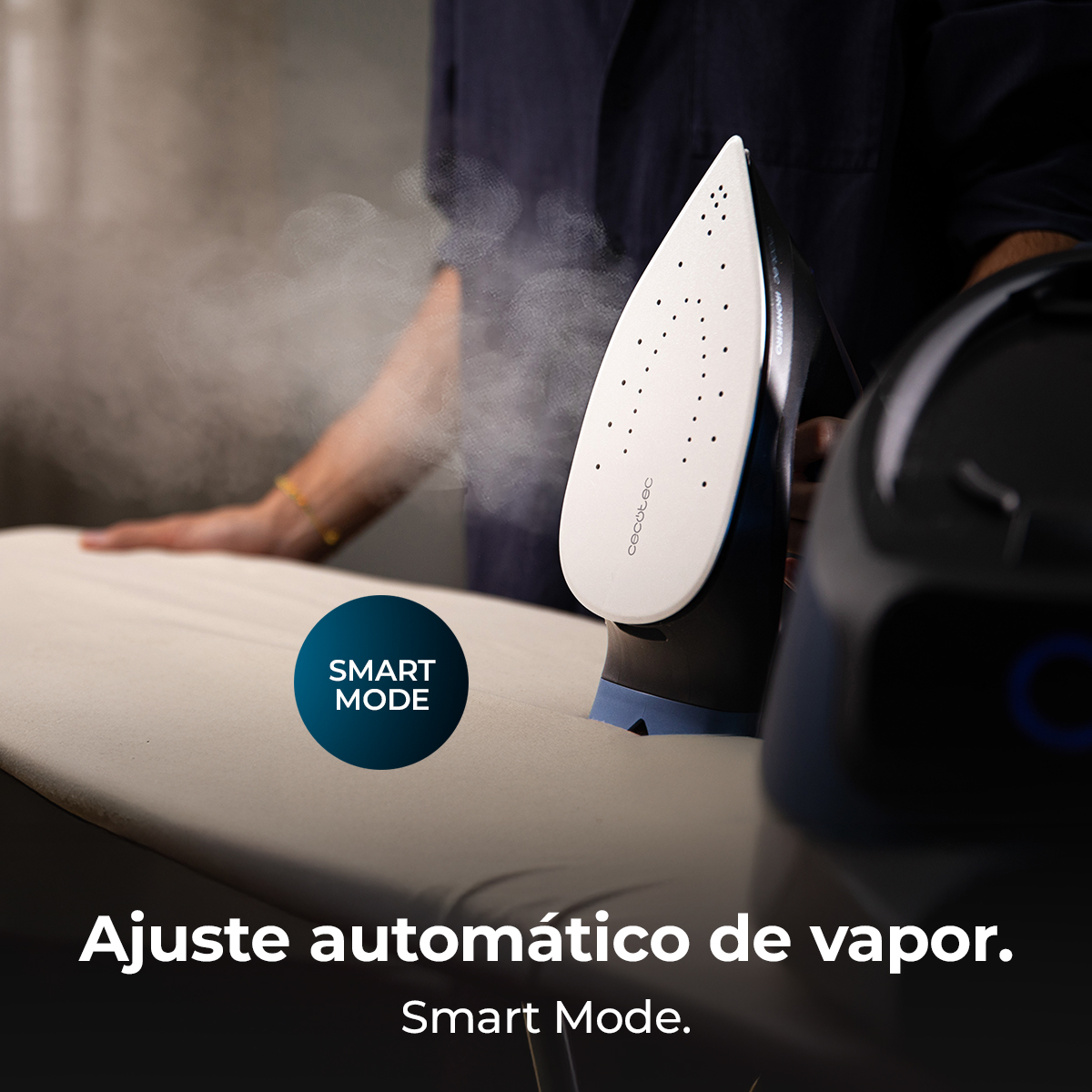 Una plancha vaporizando sobre una tabla de planchar. Una persona usa la plancha. El texto dice 'Smart Mode' y 'Ajuste automático de vapor'.