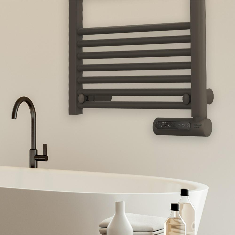 Un baño moderno con un toallero gris oscuro, una bañera y un grifo negro. Se ven botellas y toallas.